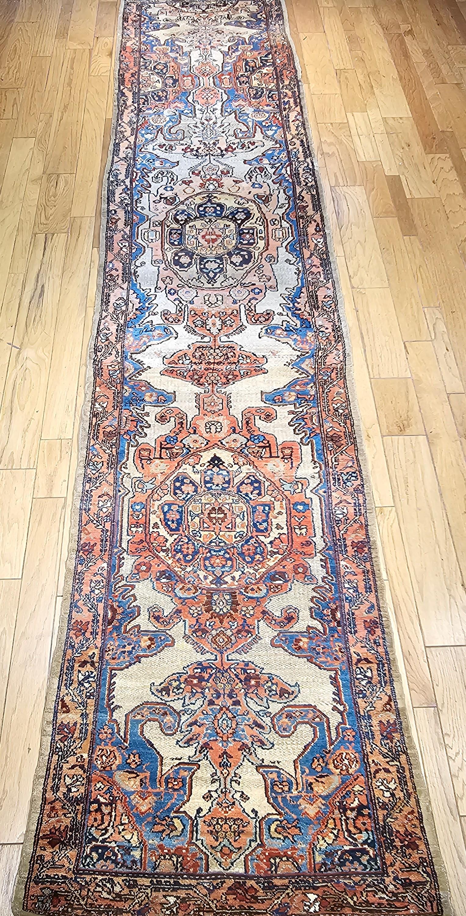 Beautiful and rare vintage Persian Malayer camelhair long runner in a unique and unusual large medallion pattern.  The design colors in the field include blue, green, pink, and yellow, and the variations on those because of the abrash effect of