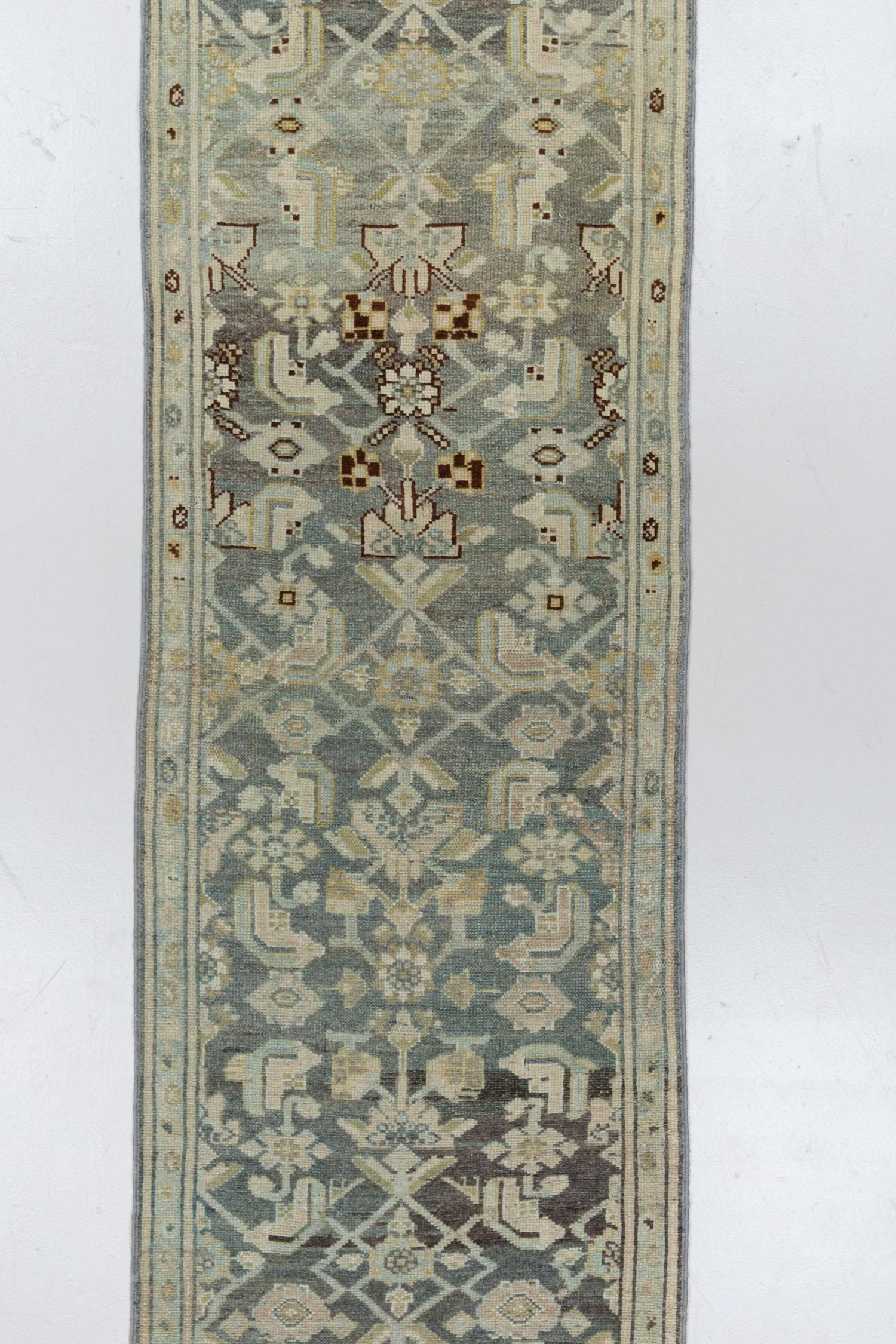 This antique Persian runner showcases a deep majestic blue field, serving as the canvas for the classic pattern that illustrates the rich heritage and craftsmanship of Persian rug weaving. The long, skinny dimensions, hard to find in the market,