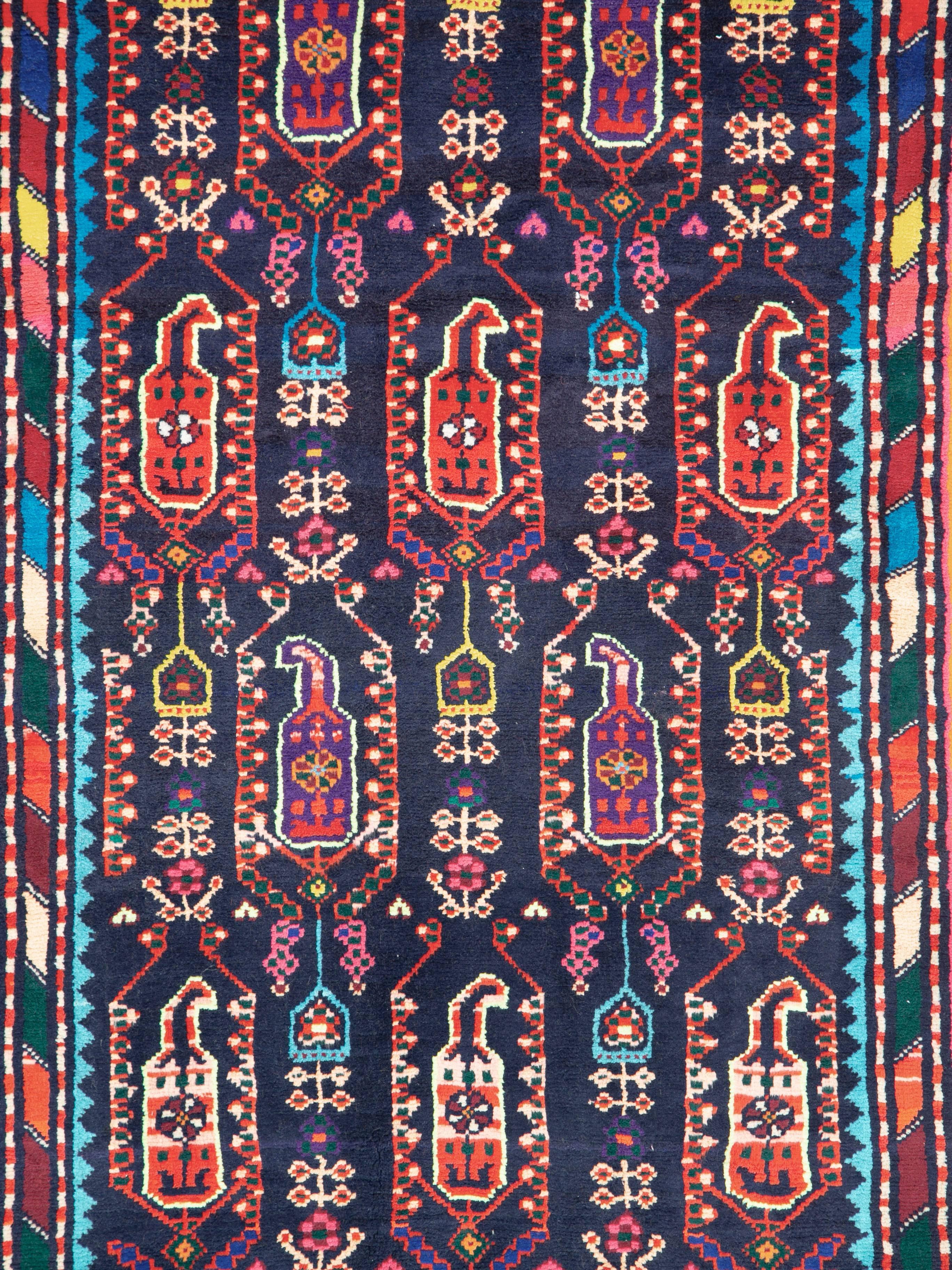 A vintage Persian Malayer folk rug in runner format from the mid-20th century. The primary field and border colors are midnight blue and orange with secondary devices that are bright and multicolored.
