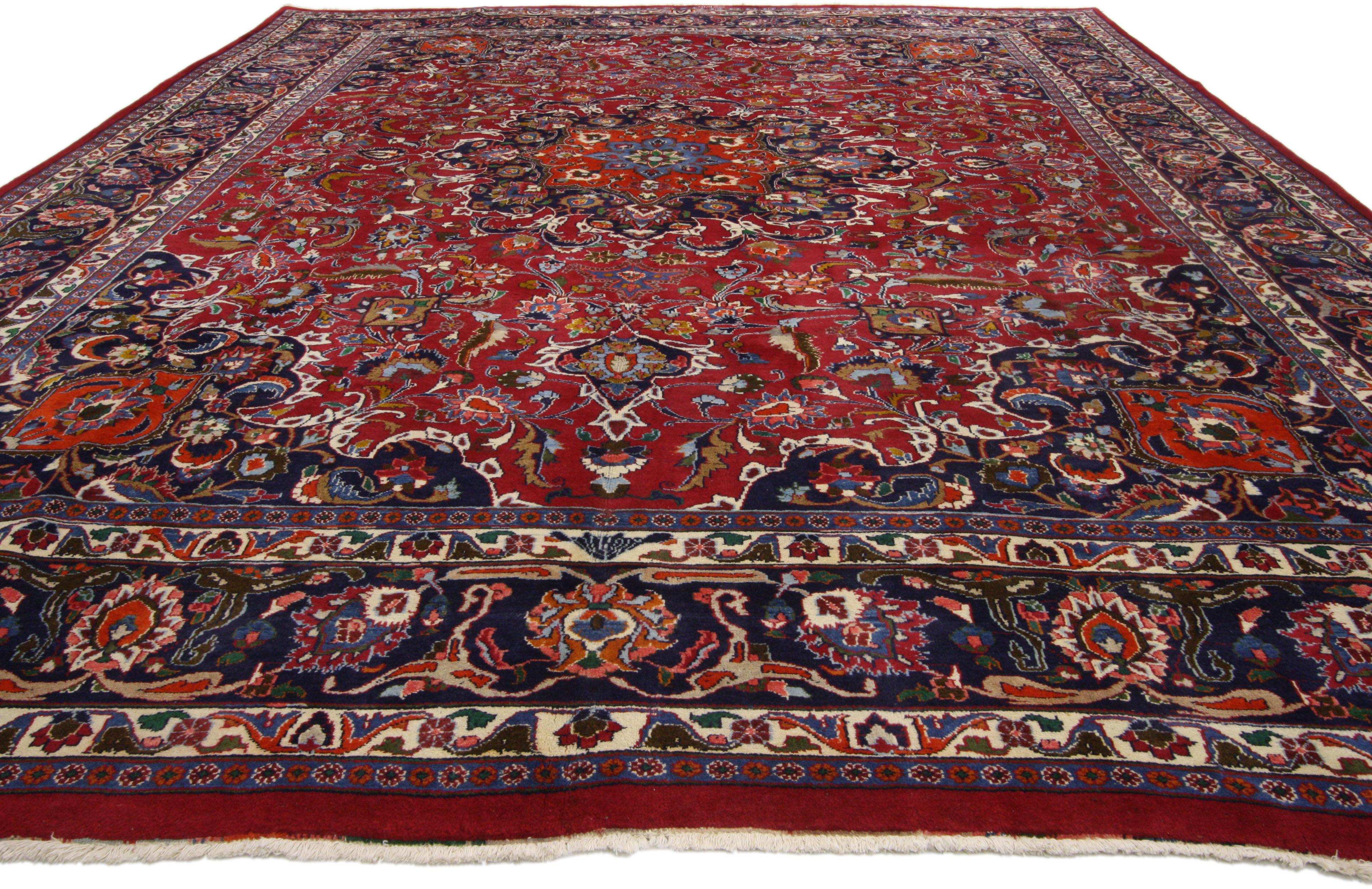 75916, vintage Persian Mashhad Area rug with traditional style. This hand-knotted wool vintage Persian Mashhad rug features a 16-point Mashhad medallion in a field of palmettes, feathers, serrated leaves and blooming flowers. The central medallion