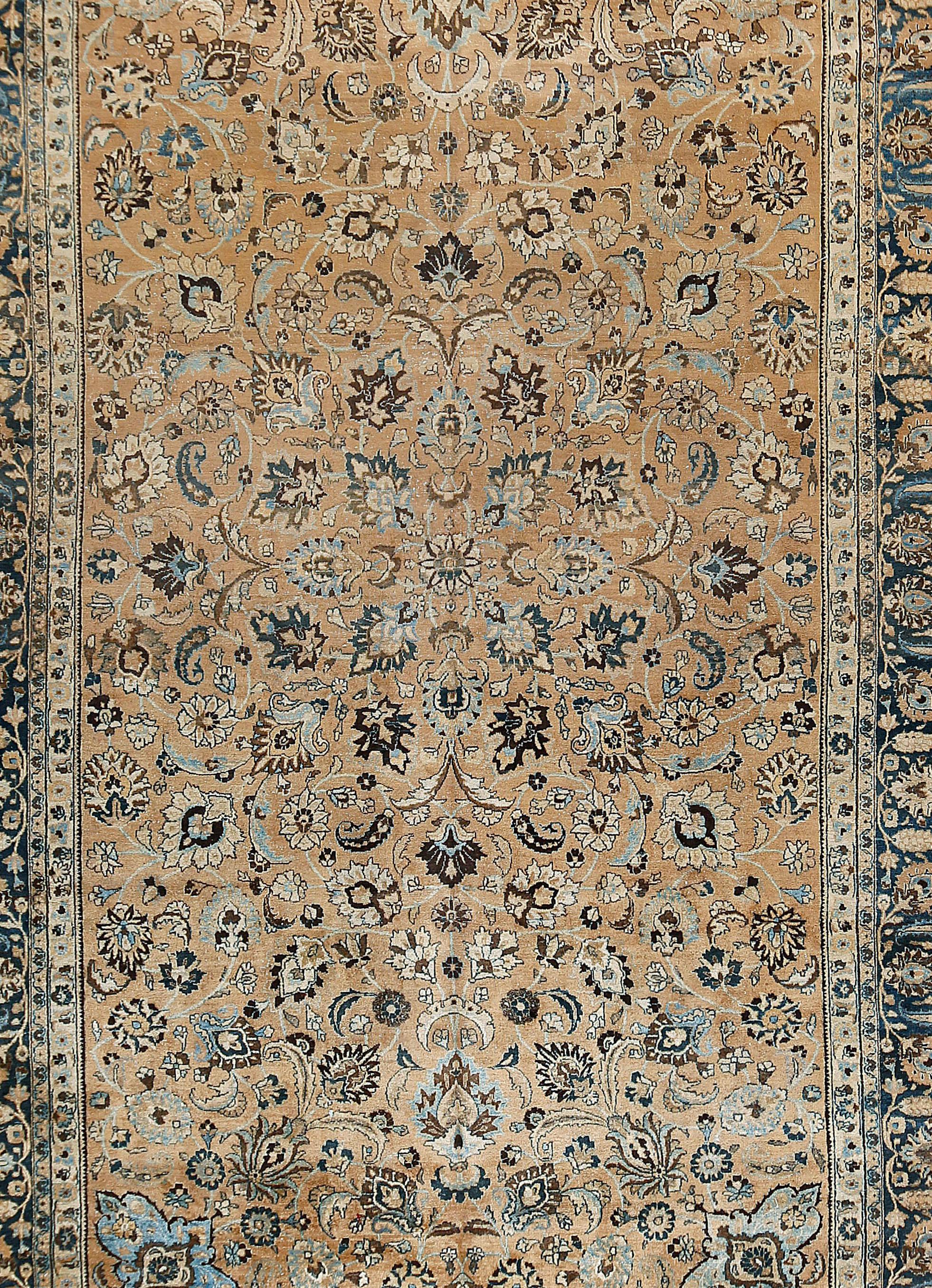Vintage Persian Meshad rug, 9'7 x 16'6. The buff field displays a focused pattern of a multitude of various palmettes, rosettes, flowering vines, botehs and floating leaves. Light blue cartouches delineate the four field corners. The pattern