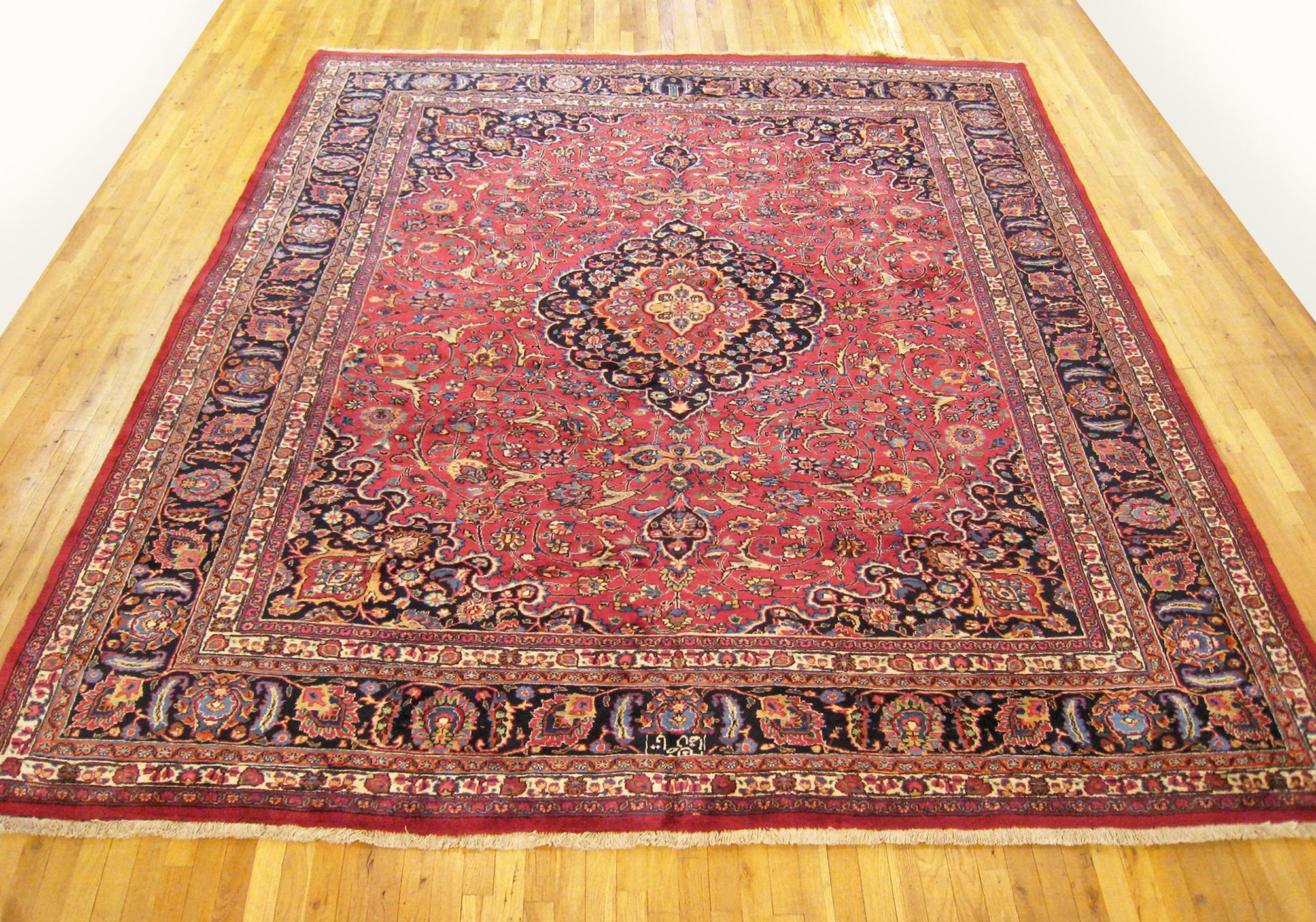 Vintage Persian Meshed Oriental Rug, Room size

A vintage Persian Meshed oriental rug, size 12'0 x 9'10, circa 1940.  This handsome hand-woven geometric rug features a central medallion with floral elements allover the red field.  The central field