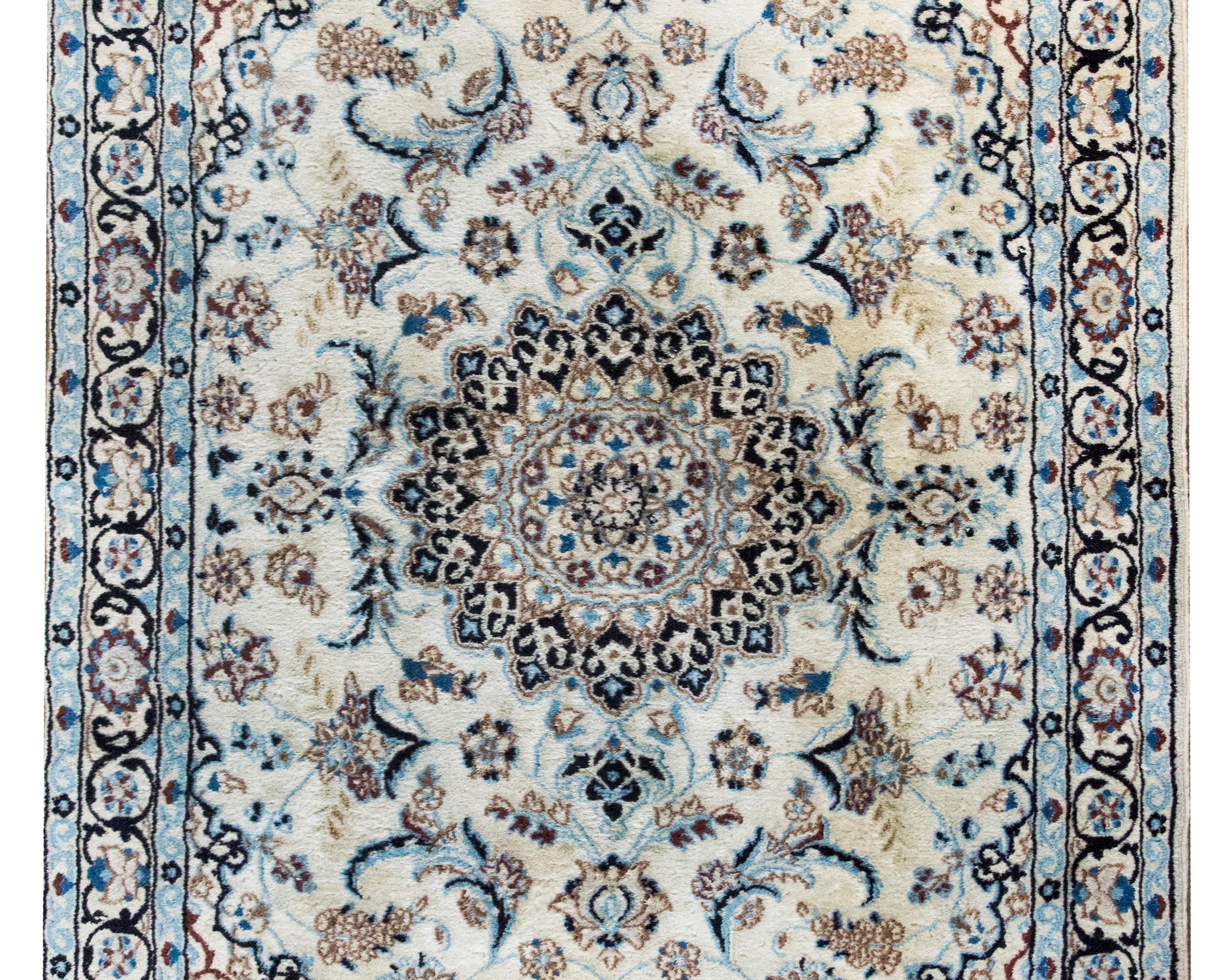 Ein wunderschöner persischer Naein-Teppich aus dem späten 20. Jahrhundert mit einem großen zentralen Blumenmedaillon inmitten eines Feldes mit weiteren Blumen und Blättern, umgeben von einer kunstvollen Bordüre mit noch mehr Blumen und Ranken.  Der