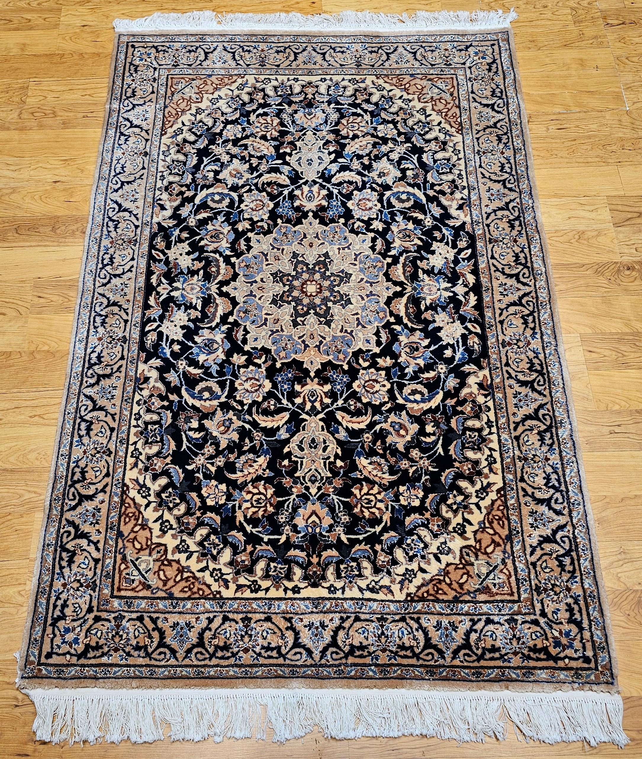 This vintage hand-knotted Persian Nain rug from the 3rd quarter of the 1900s showcases exquisite craftsmanship with an exceptionally fine weave and shimmering silk highlights throughout both the field and border.
Set against a deep navy blue field,