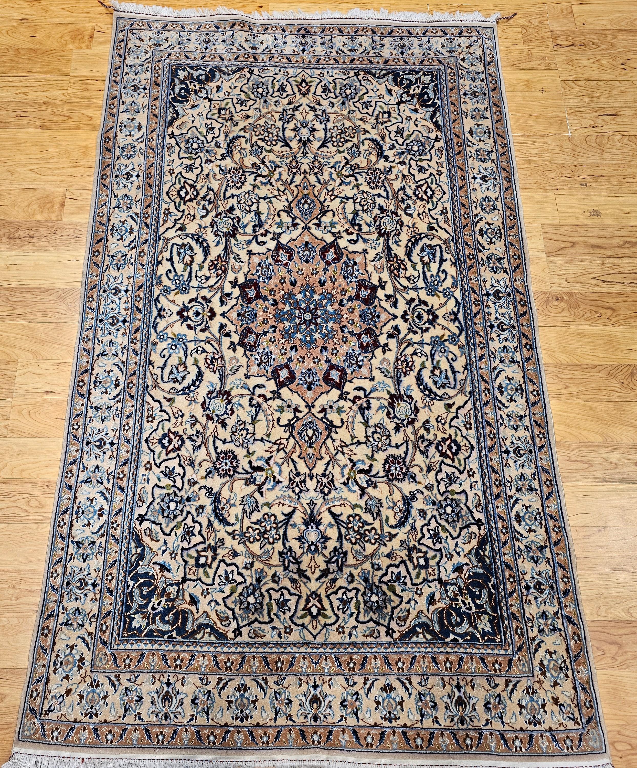 Questo tappeto persiano vintage di Nain, risalente al terzo trimestre del 1900, è uno splendido esempio di arte persiana classica. Caratterizzato da un dettagliato motivo floreale e da un importante medaglione centrale, il tappeto è disposto su un