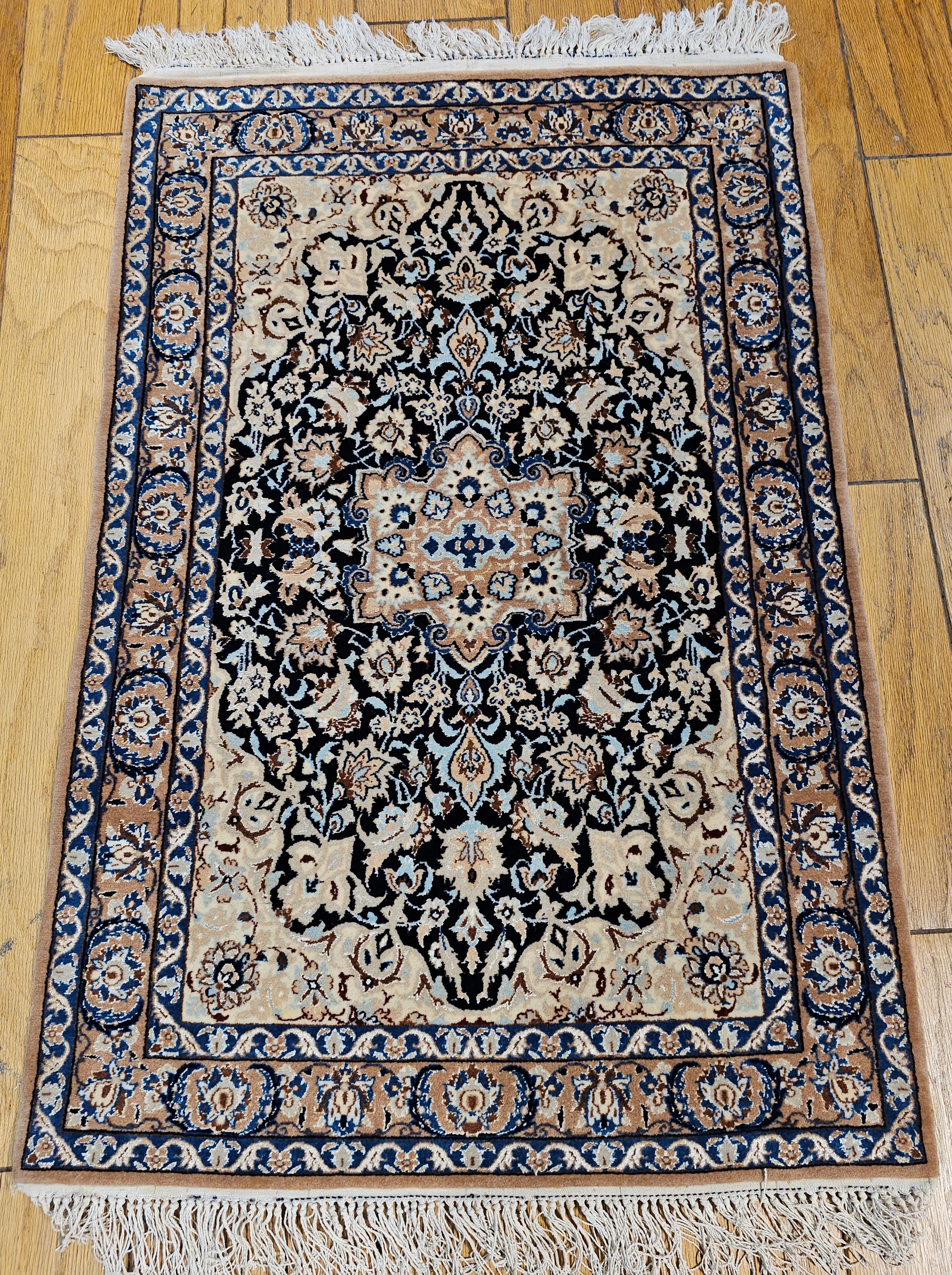 A handwoven Nain area rug from the 3rd quarter of the 1900s with a fine weave with Tiffany and French Blue colors.   This Nain rug has a beautiful floral design set in a rich navy blue field color with a beige color border.  The design colors in the