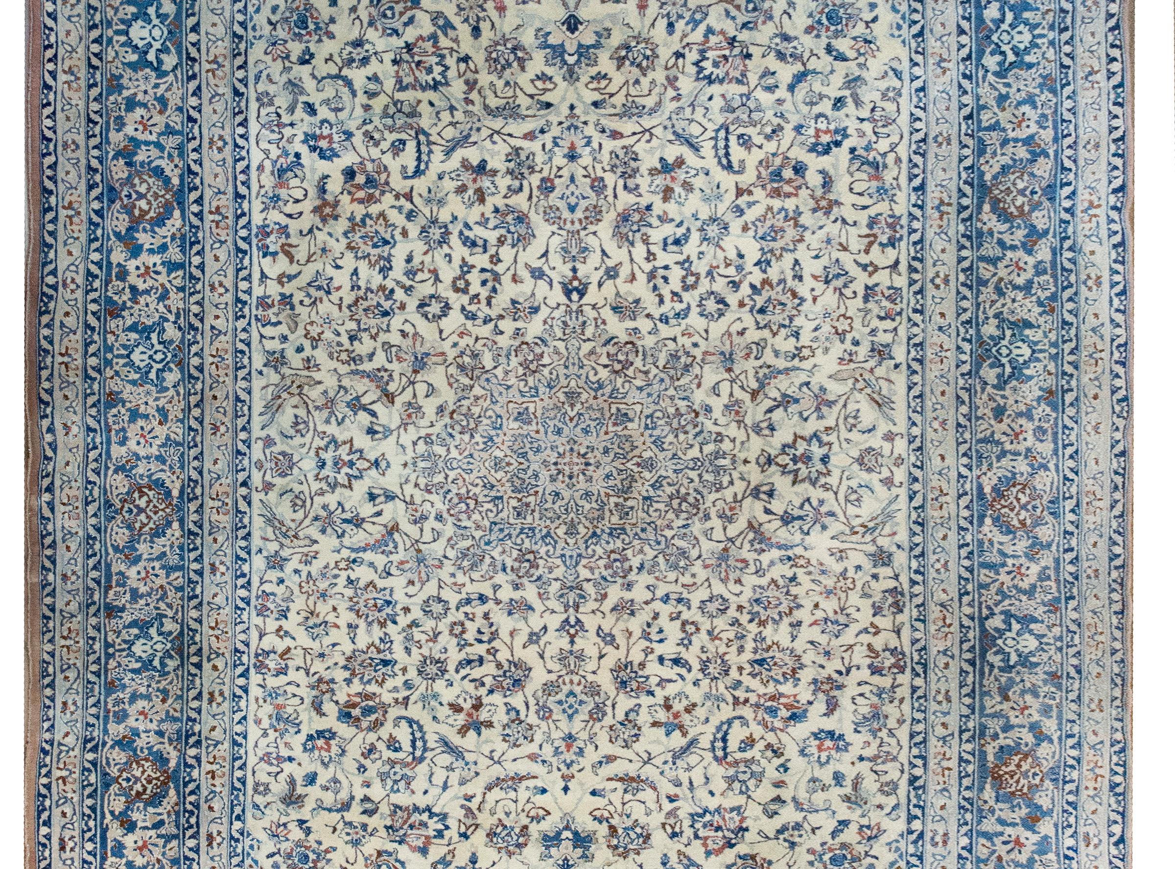 This exquisite late 20th-century Persian Rain rug is a masterpiece of traditional craftsmanship. Its design centers on a grand medallion that radiates elegance and draws the eye, set amidst a field of intricately woven flowers and scrolling vines.