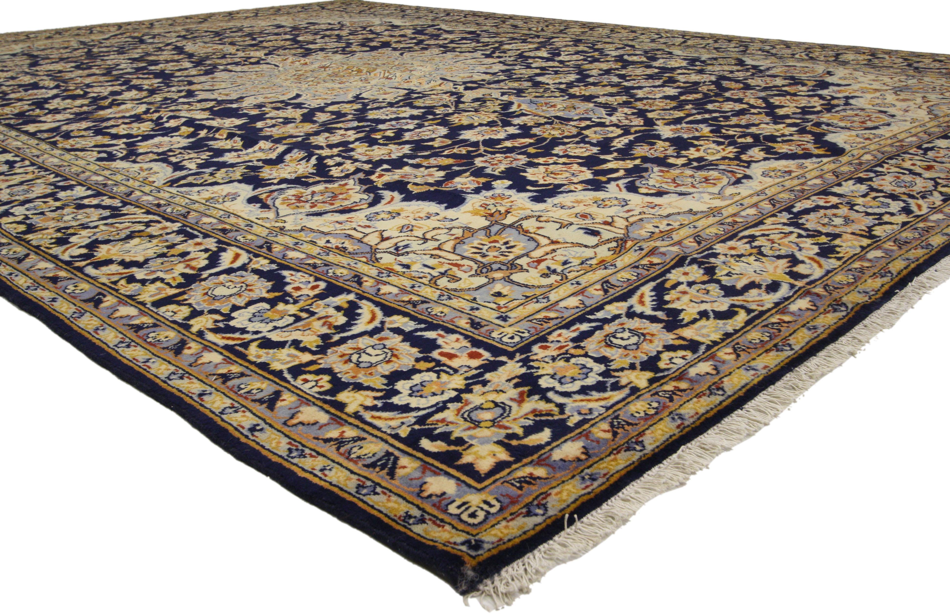 76013, alter persischer Najafabad-Teppich im romantischen arabesken Barock-Stil. Dieser handgeknüpfte persische Najafabad-Teppich aus Wolle zeigt ein zentrales Blumenmedaillon und ein florales Allover-Muster auf einem tintenblauen Feld. Eingerahmt