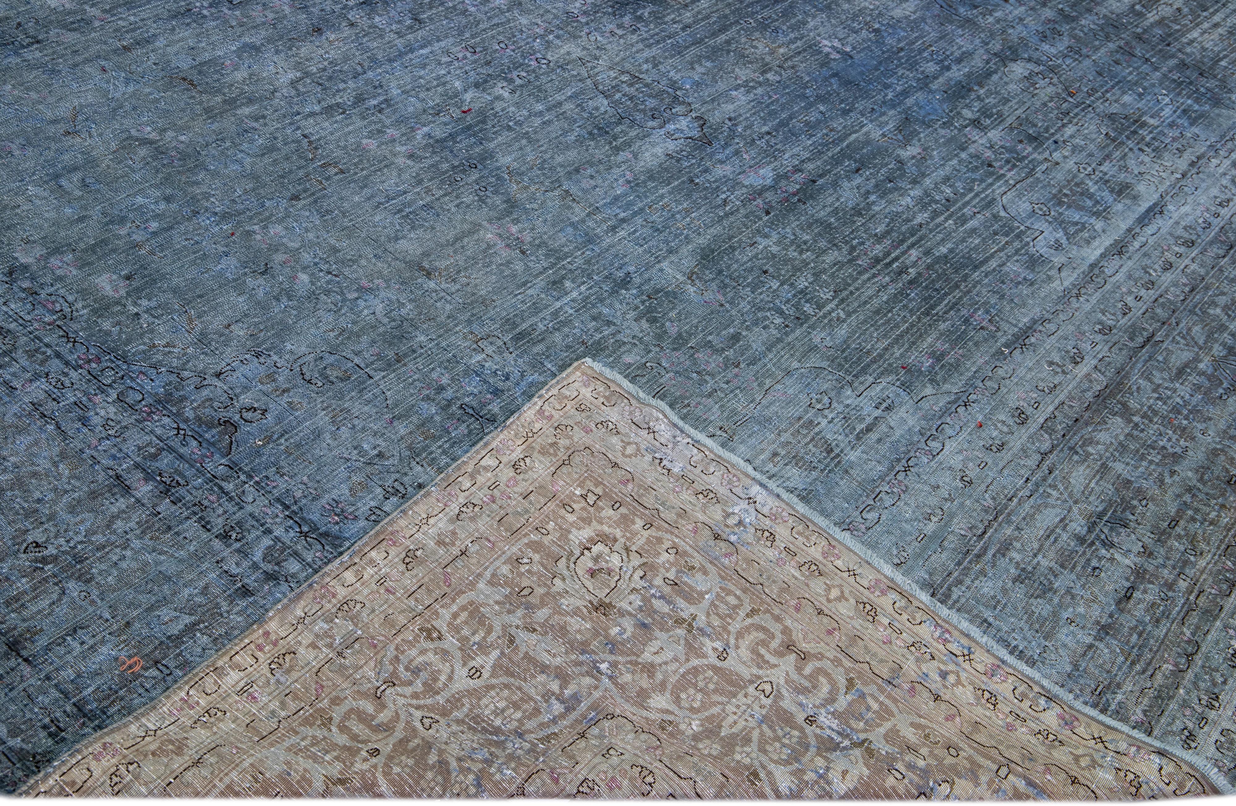 Beautiful Vintage Overdyed hand-knotted wool rug with a blue field. This Persian rug has black and gray accents in an all-over medallion design.

This rug measures: 10'9