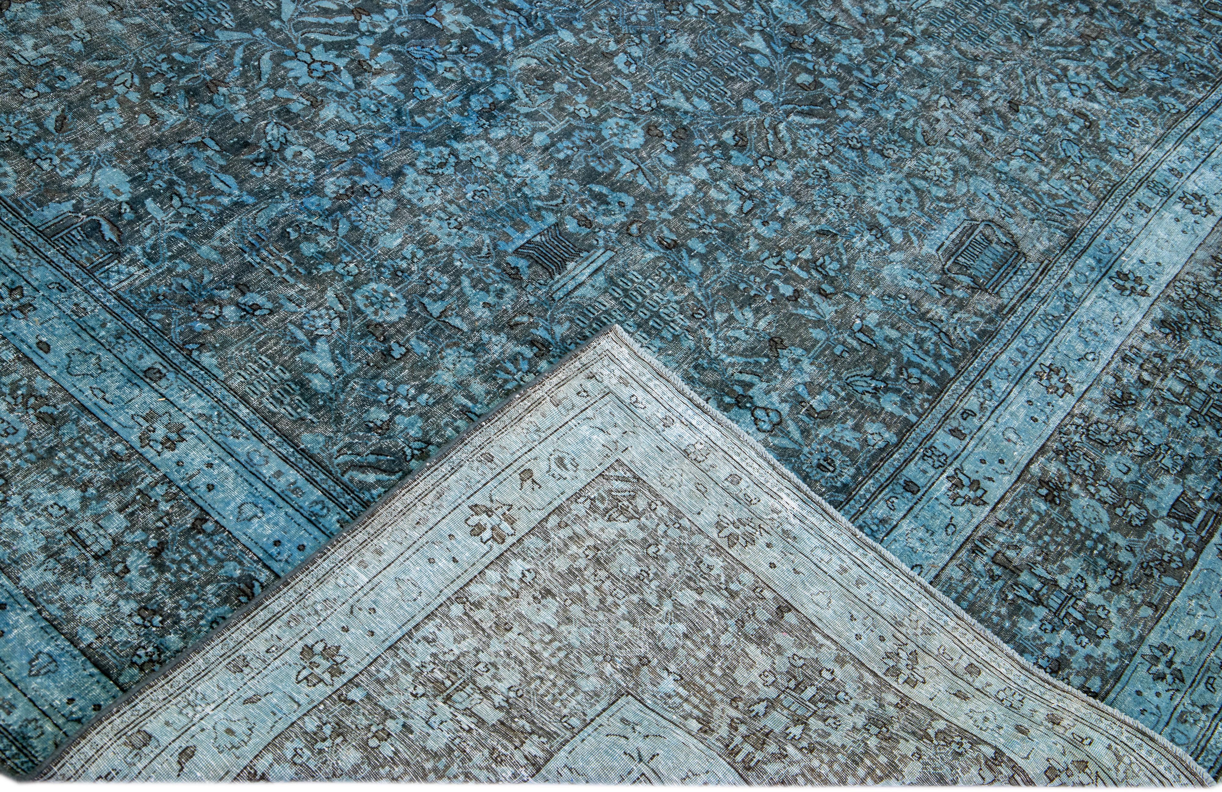 Magnifique tapis vintage en laine surteinte nouée à la main avec un champ bleu. Ce tapis persan présente un cadre gris et un motif floral sur toute sa surface.

Ce tapis mesure : 8'9