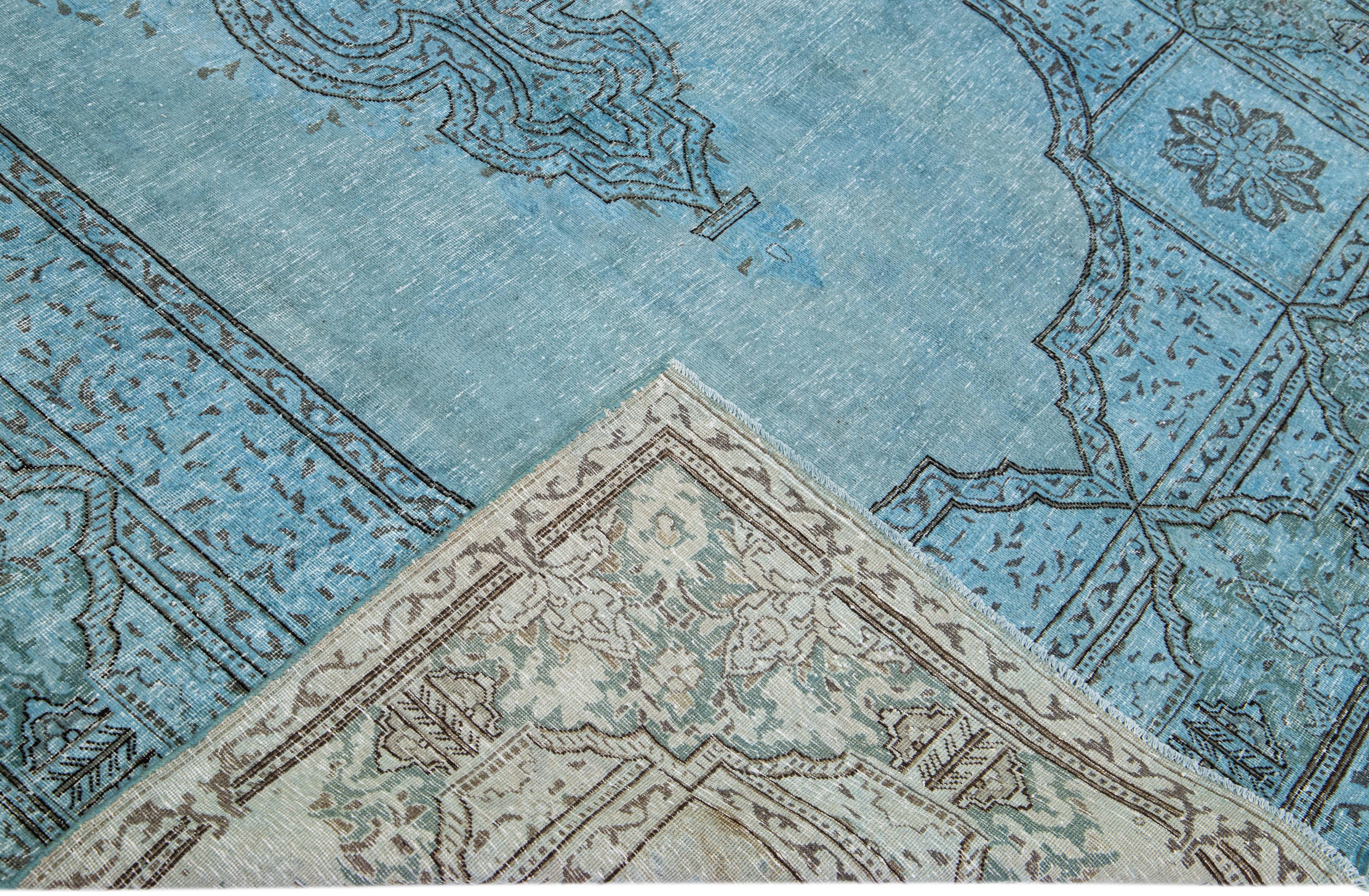Beautiful vintage overdyed hand-knotted wool rug with a blue field. This Persian rug has black and gray accents in an all-over medallion design.

This rug measures: 6'9
