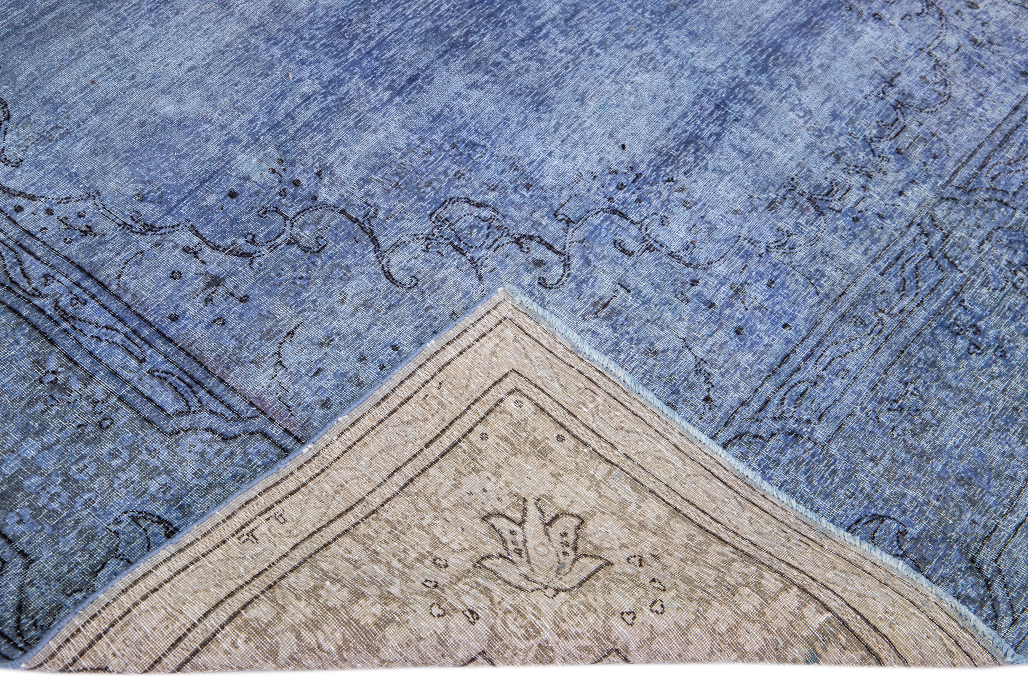 Beautiful Vintage Overdyed hand-knotted wool rug with a blue field. This Persian rug has gray and black accents in an all-over medallion design.

This rug measures: 6'11