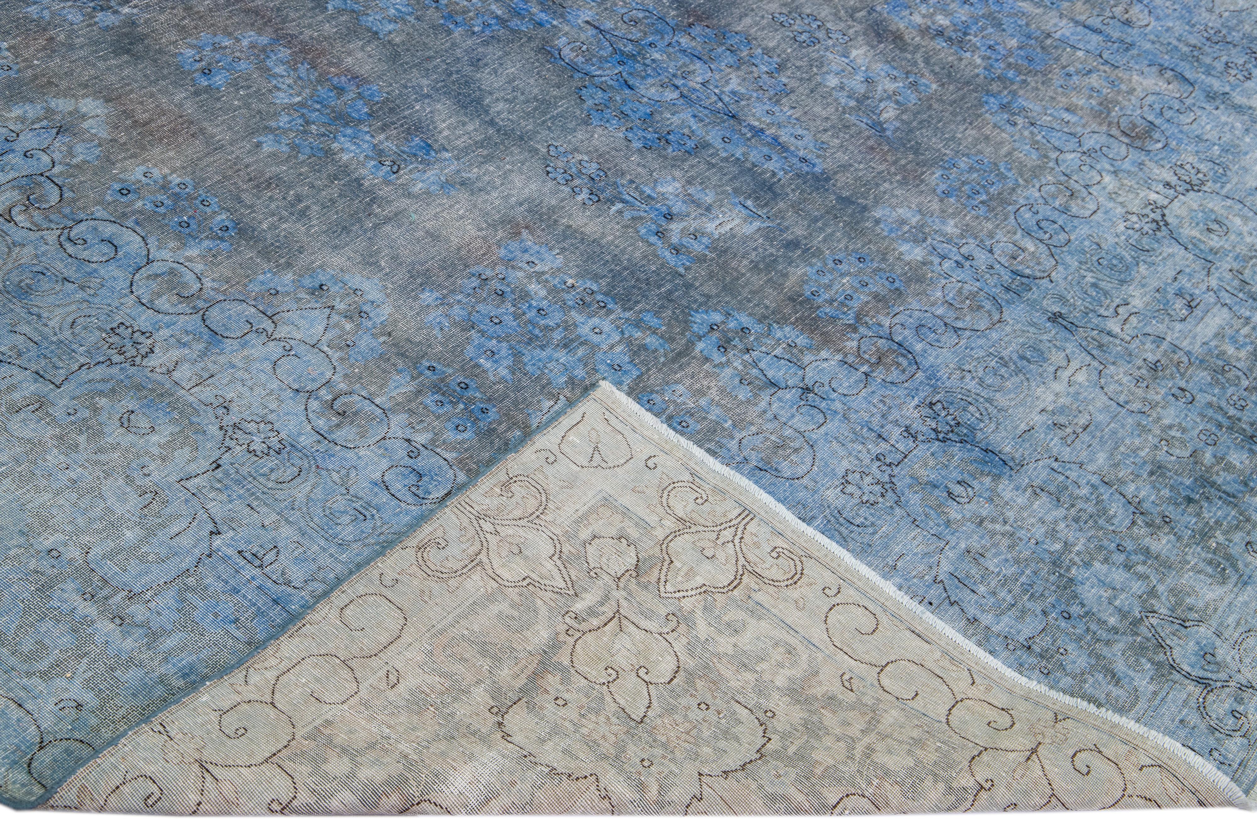 Beautiful Vintage overdyed hand-knotted wool rug with a blue field. This Persian rug has gray accents in an all-over medallion floral design.

This rug measures: 9'8'' x 13'3