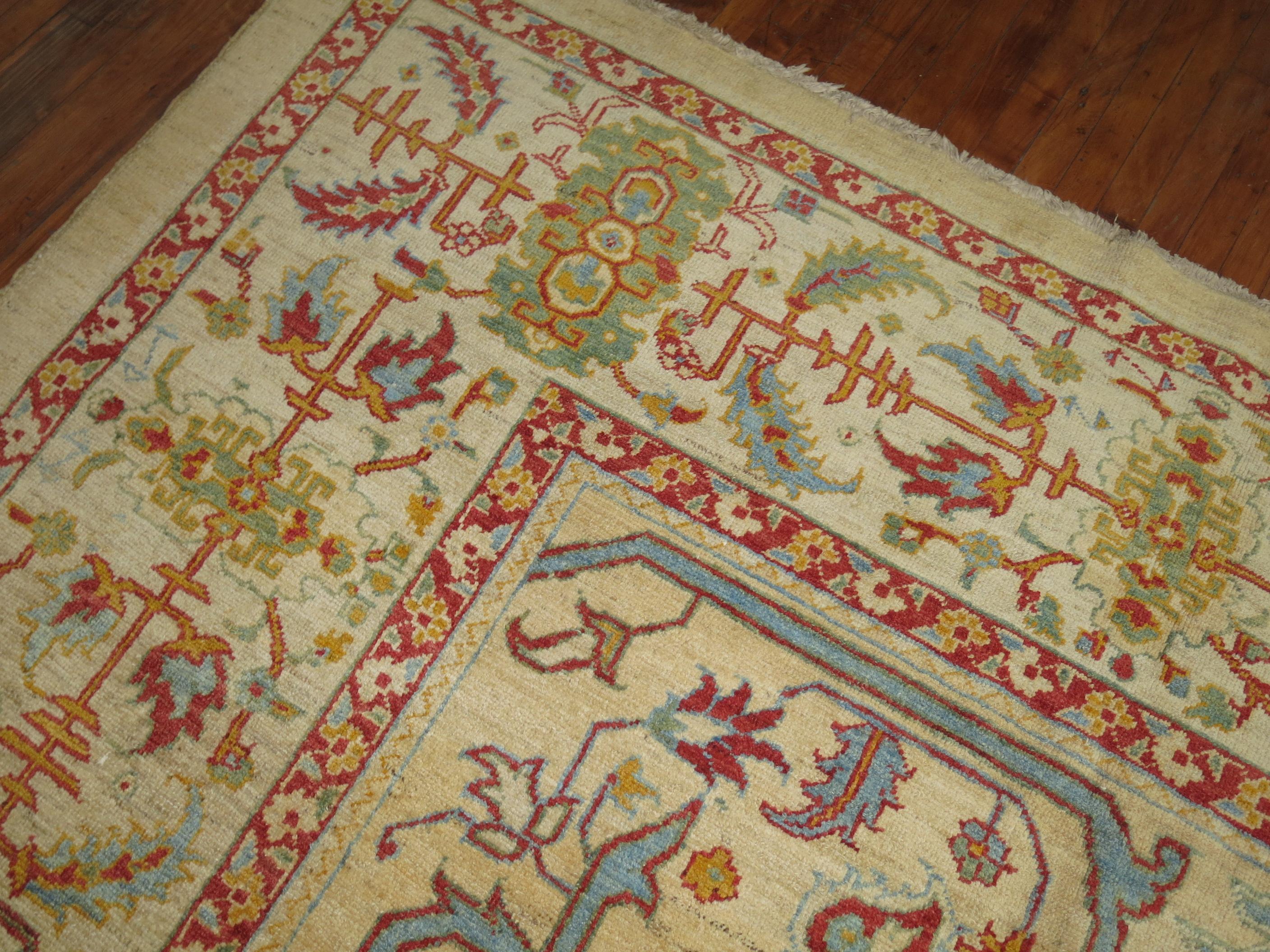 A highly unusual decorative large vintage Persian rug which was woven to replicate an old Turkish Oushak. The enriched colors in the piece include a camel field with strawberry reds, robin eggs blue, lime green, burnt orange and an ivory border. The