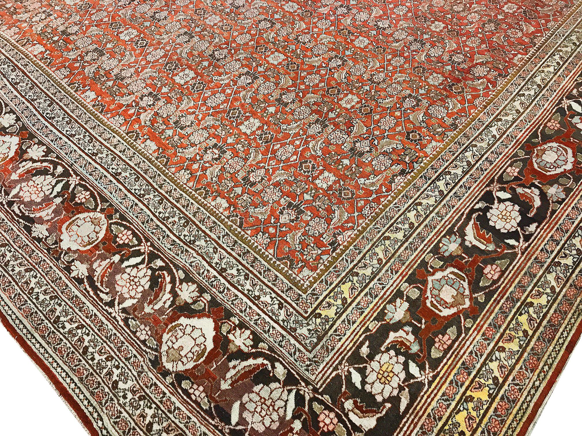 Vintage Persian Oversize Tabriz rug carpet. Measures: 11' x 17'5. A vintage circa 1940s Tabriz handwoven rug. The central field with floral themed designs surrounded by a commanding main border to give the rug a soft yet powerful look. The rug is in