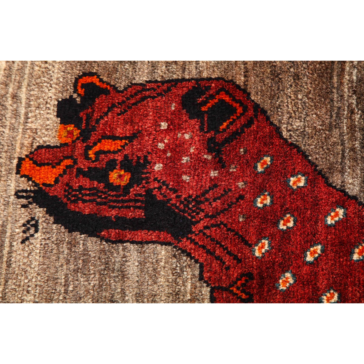 This vintage Persian Qashqai Kashkooli leopard animal carpet, circa 1930 in pure handspun wool and organic vegetable dyes has a unique coloration of undyed cream, beige and gray wools and contrasting dyed red, burgundy and orange tones. The