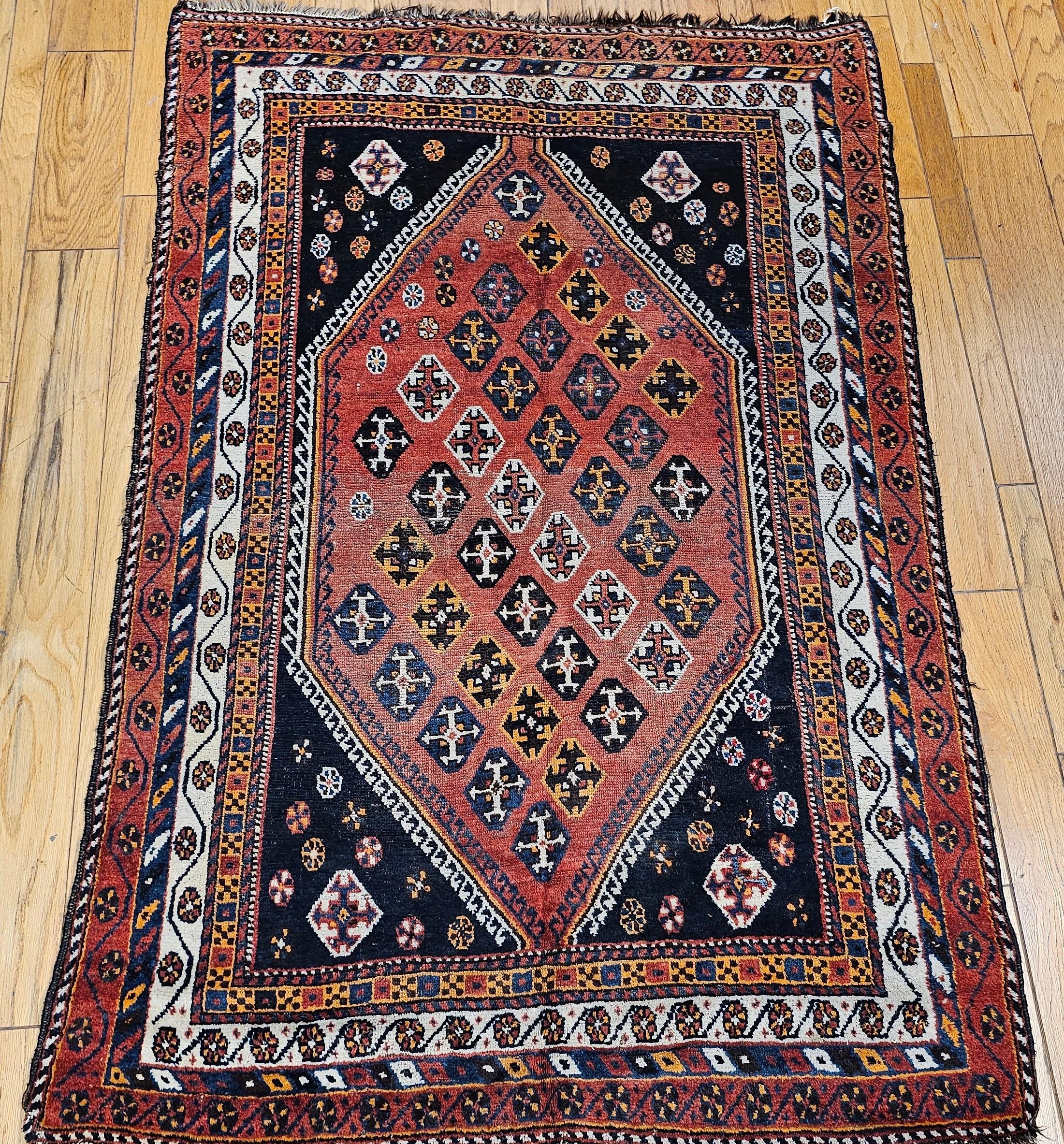 A wonderful Qashqai tribal carpet from the early 1900s from southwest Persia.  A large medallion almost covers the whole rug with small geometric designs in various colors set throughout the medallion.  It has dark blue spandrels with small