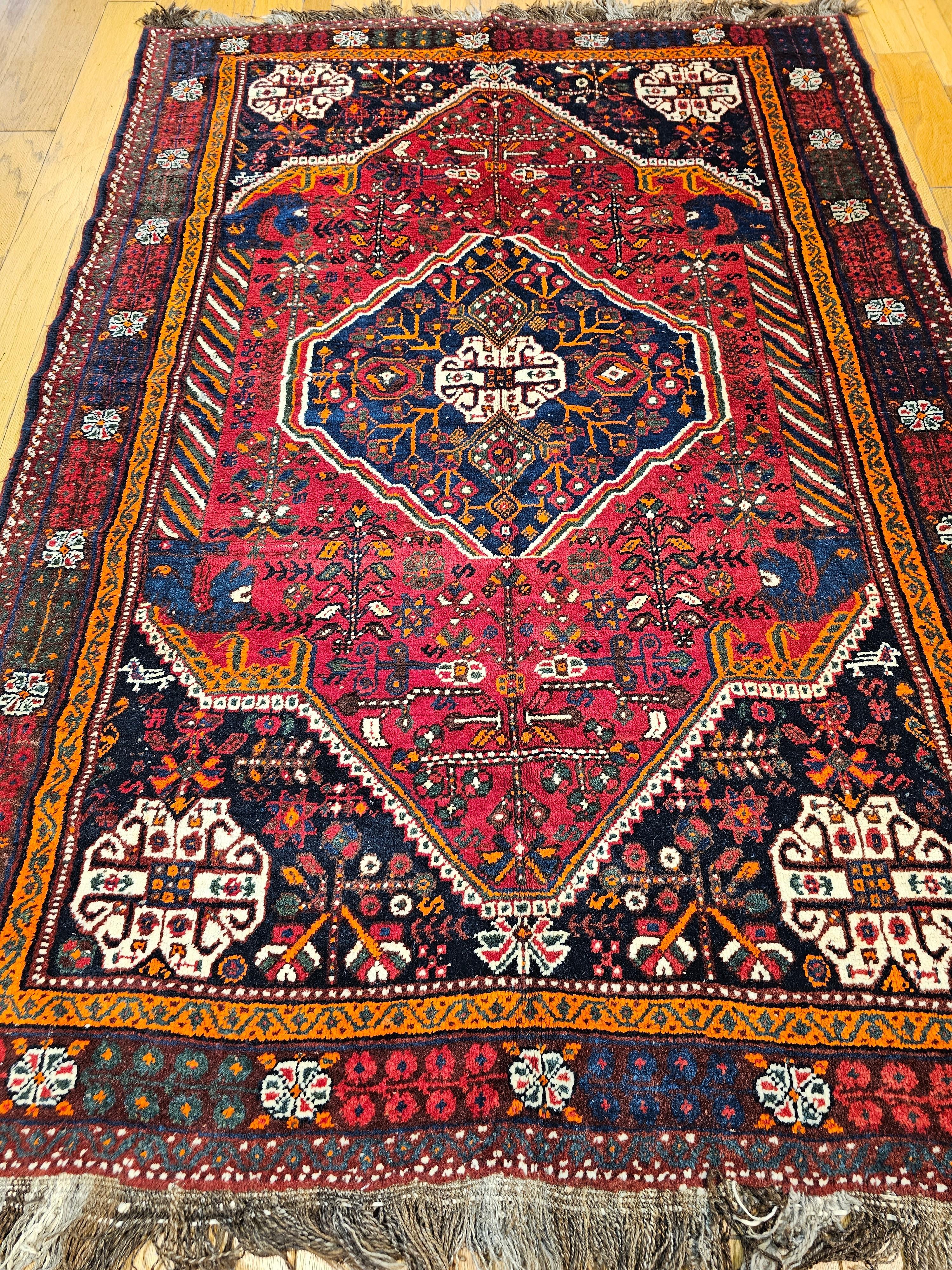 Vintage Persian Qashqai(Ghashghai) tribal carpet from Southwestern Persia circa the mid 1900s.   The Qashqai rug has a traditional tribal design format which includes one central medallion and four small medallions in the corner spandrels. It has a