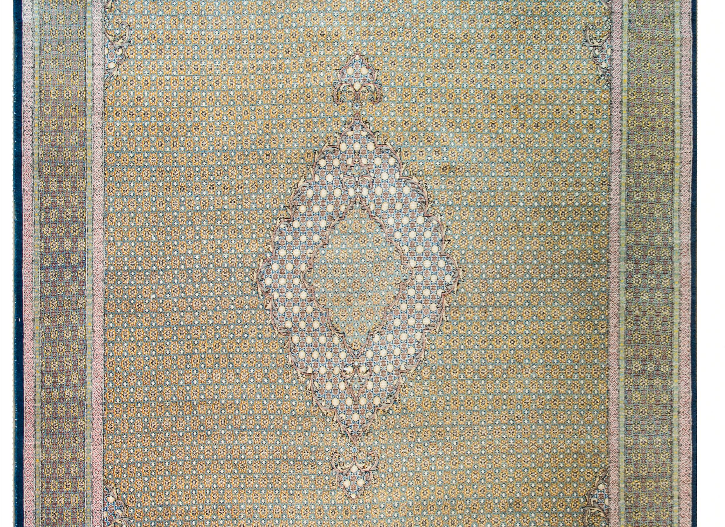A mesmerizing mid-20th century Persian Qum rug with the most elaborately woven pattern containing myriad tiny stars in a reputed pattern across the field, and arranged with alternating colors to create a medallion in the center, and woven in