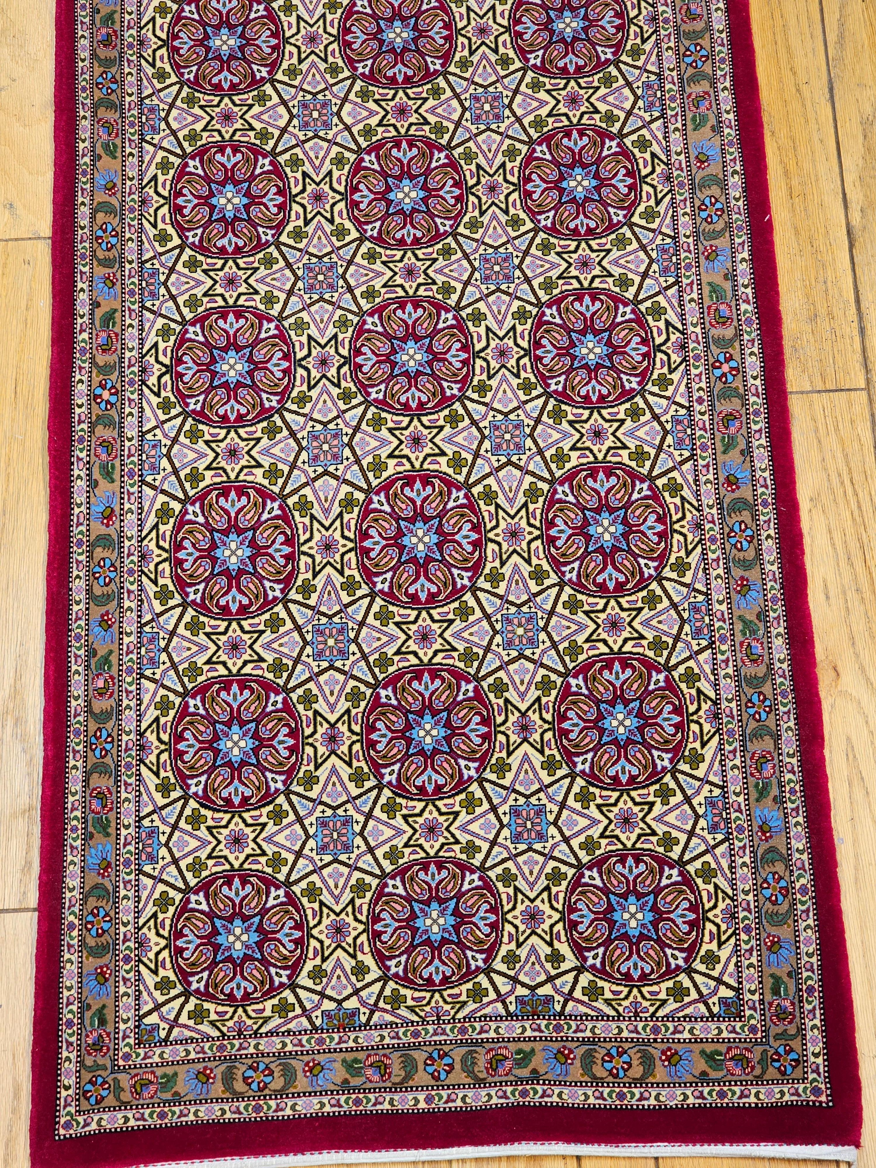  Beautiful Persian Qum runner in a rare geometric design.  The Qum runner design includes circles that have the paisley design in them in a light yellow field framed in a narrow border with flower designs in cream, red, blue, and green.  Qum rugs