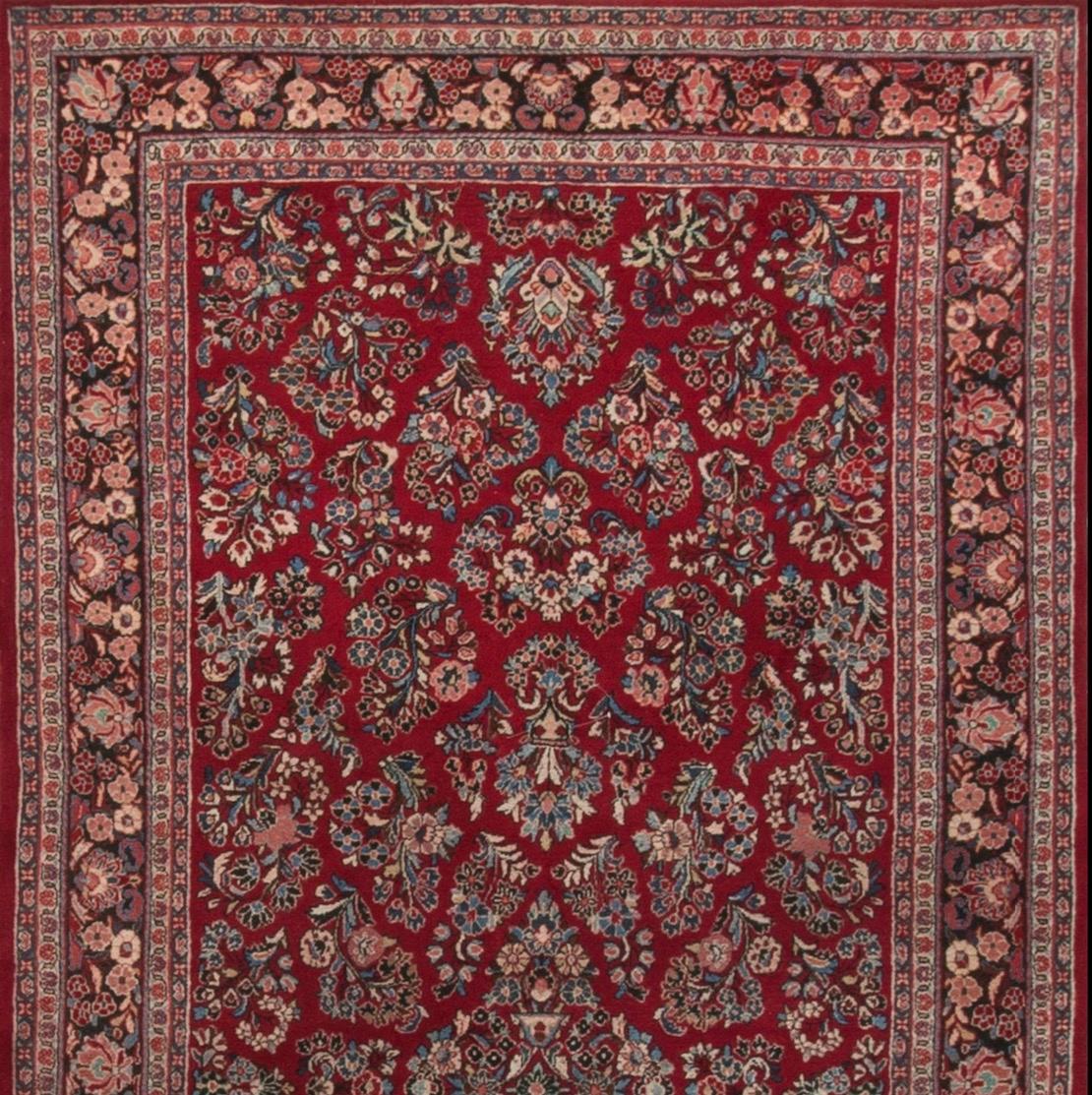 Questo antico tappeto persiano Sarouk, risalente al 1940 circa, presenta un design classico e raffinato. I tappeti Sarouk sono noti per i loro motivi floreali e per i disegni intricati. Il campo centrale di questo tappeto mostra probabilmente