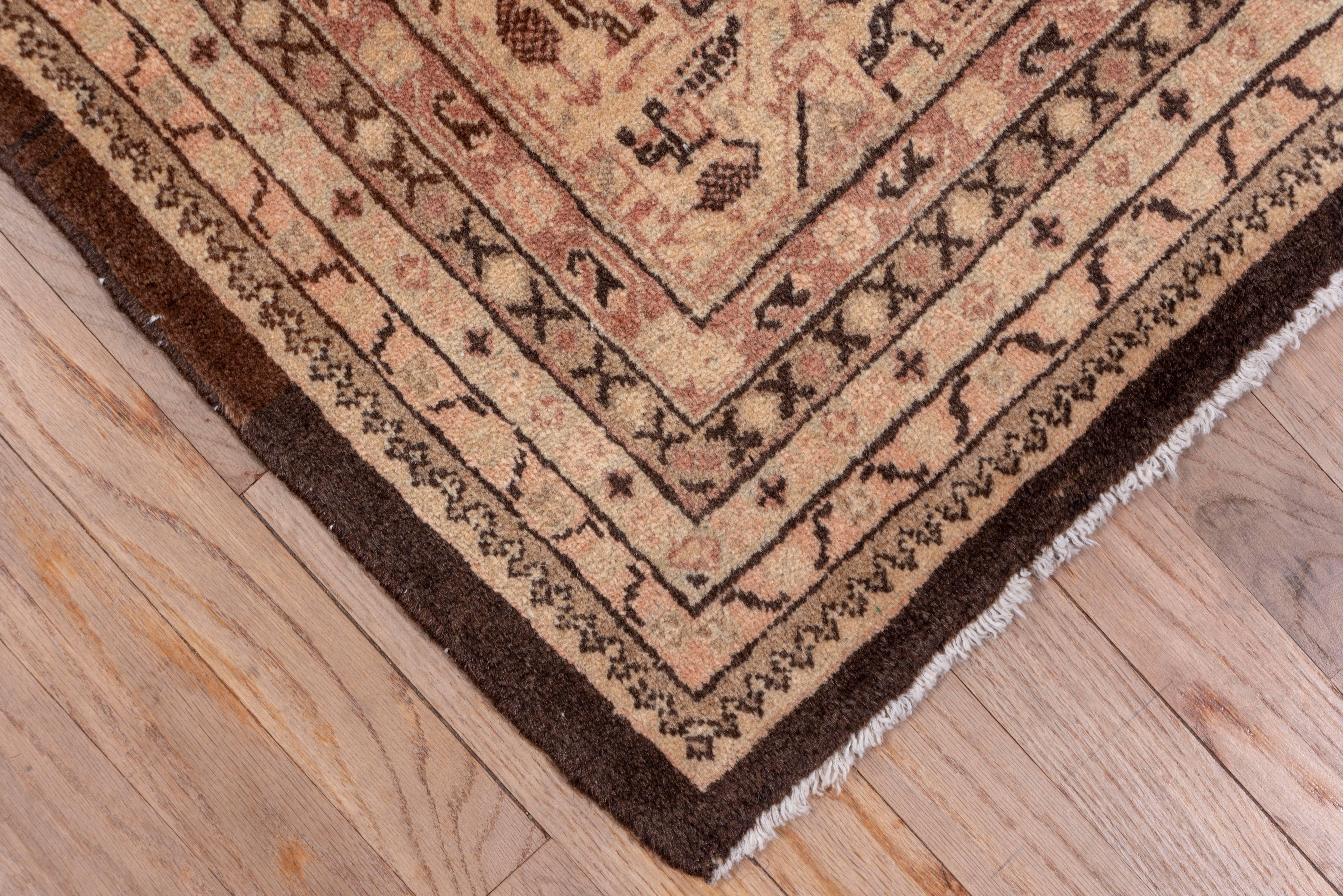 In the Saraband style, this west Persian urban carpet has a brown field with numerous half drop rows of tiny angular bottehs, and a border system with a central old ivory band with an angular vine and hanging bottehs. There are eight further