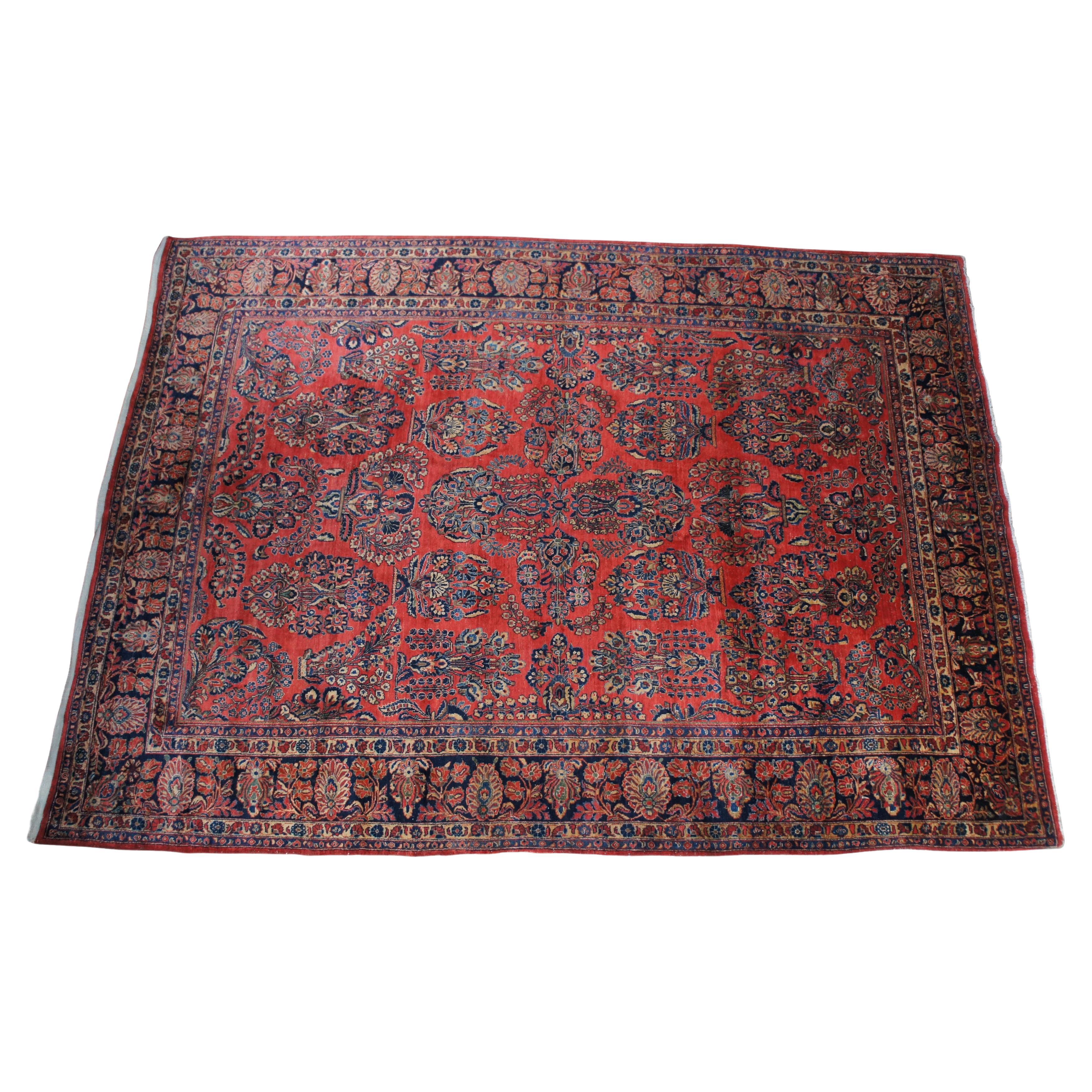 Large vintage Persian Sarouk area rug / carpet featuring a floral motif with red field accented with blues and tans.

The history of Persian Sarouk rugs can be traced back to the late 19th and early 20th centuries. The town of Sarouk, has been a