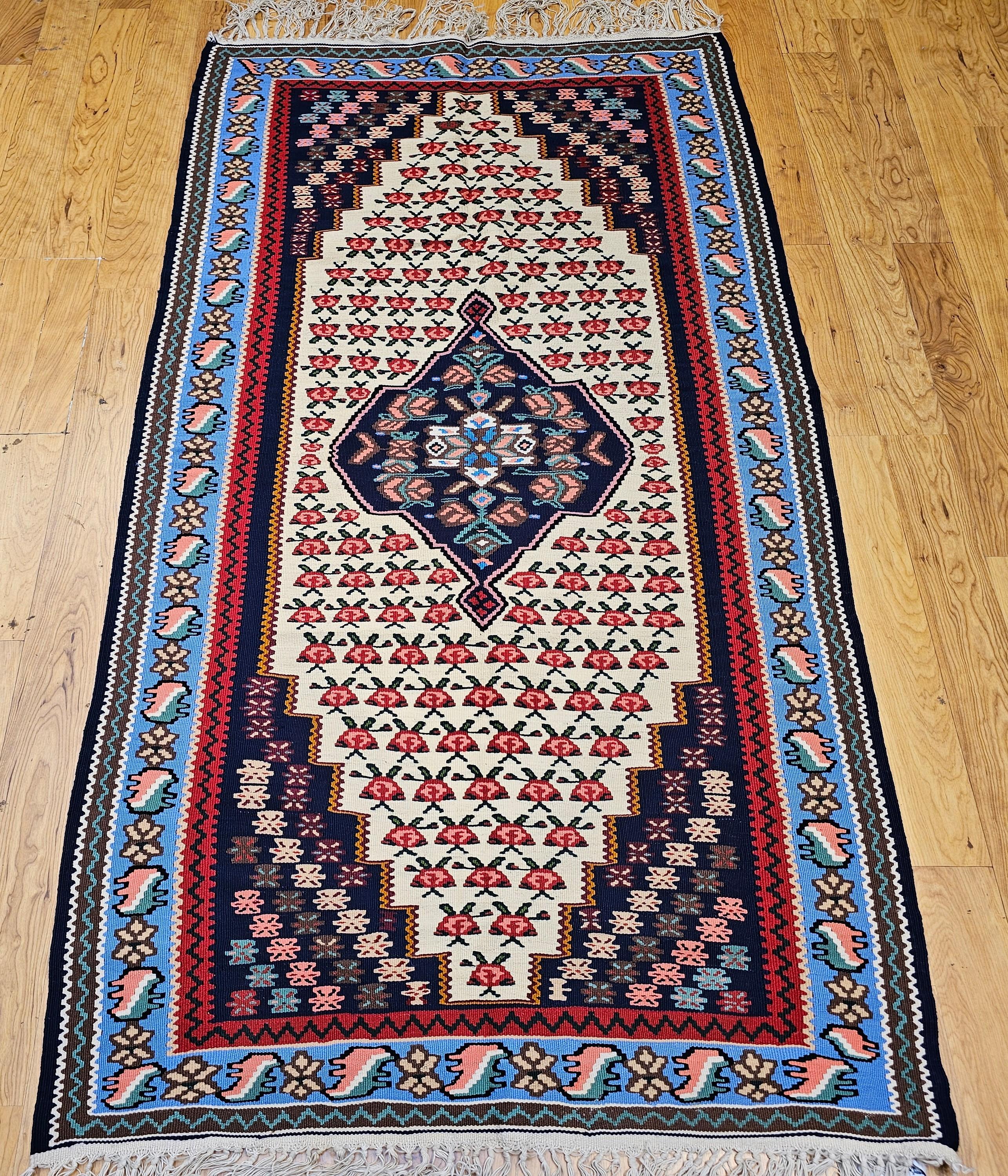Bellissimo tappeto persiano vintage Senneh (Bidjar) Kilim proveniente dalla regione del Kurdistan, nella Persia occidentale. Il kilim Senneh presenta un medaglione centrale con un disegno geometrico in blu scuro e disegni in rosso, crema e giallo. 