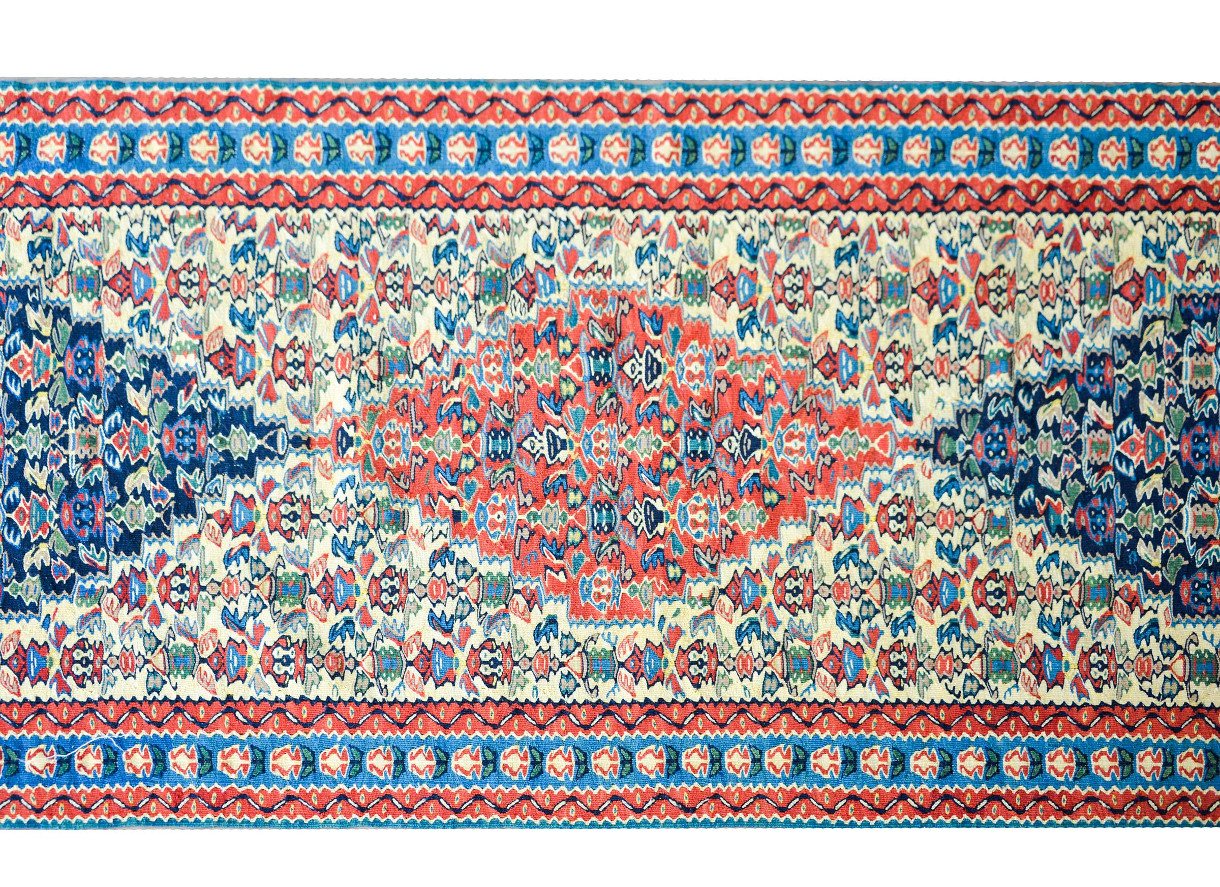 An incredible vintage Persian Senneh kilim runner with the most intensely woven all-over floral pattern with several diamond medallion in crimson and indigo amidst a yellow background. The border is beautiful with a simple petite floral patterned