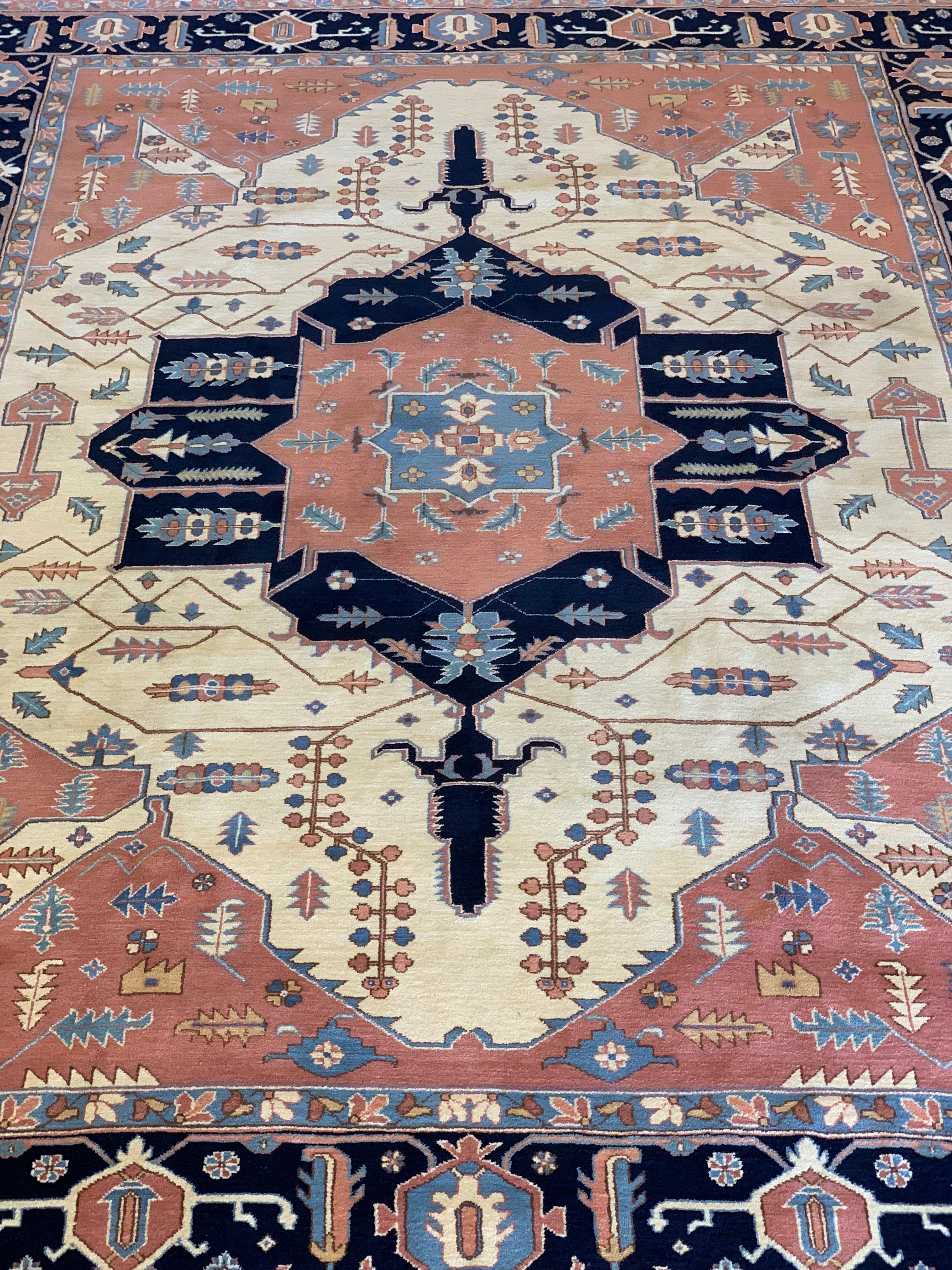 This is a signed, vintage hand-knotted Persian Serapi rug, probably woven in Romania, circa 1940s. It is wool knots on cotton warp and weft, and is approximately 8’10 x 12’2 ft. We say probably Romania because many people think or say that all