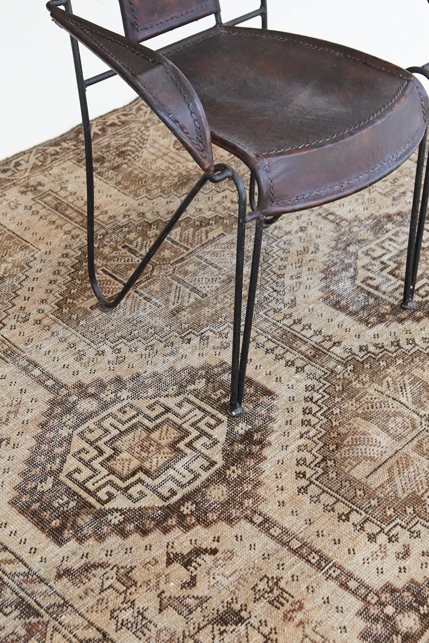 This sophisticated Persian Shiraz vintage rug features a beautiful natural wool pile. It is adorned with cinnamon and a neutral tone that ensembles motifs and symbols following Cyrus' horses. Series of grandiose medallions, geometrical motifs, and