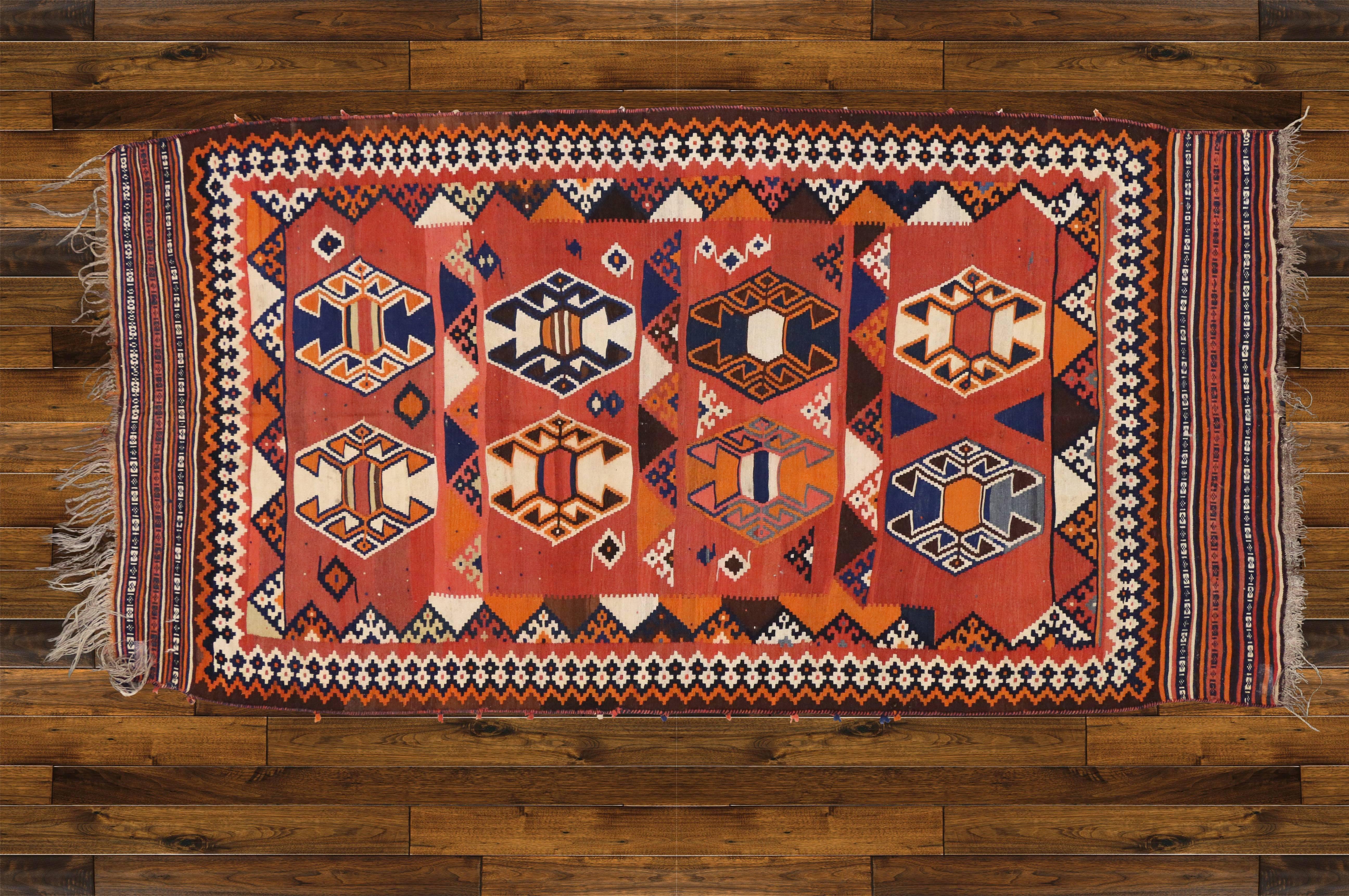 70606, vintage Persian Shiraz Kilim rug with tribal style. This vintage Persian Shiraz Kilim rug features four rows each filled with two large scale ram's horn motif in vibrant colors. The ram's horn symbolizes power, masculinity, fertility and