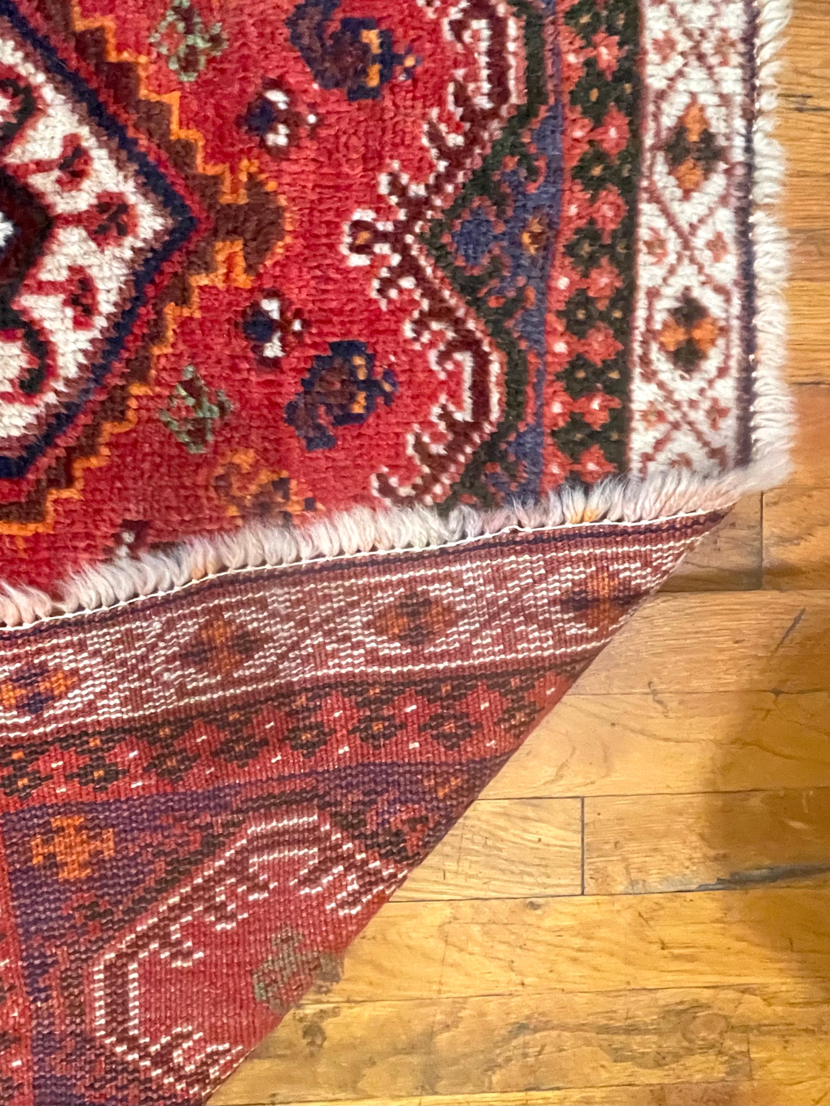 Dieser Teppich ist ein authentisches Stück aus Shiraz, Iran, einer Region, die für ihre reiche Tradition handgewebter Teppiche bekannt ist. Ganz aus Wolle gefertigt, zeigen sowohl der Flor als auch der Unterbau die Strapazierfähigkeit und den