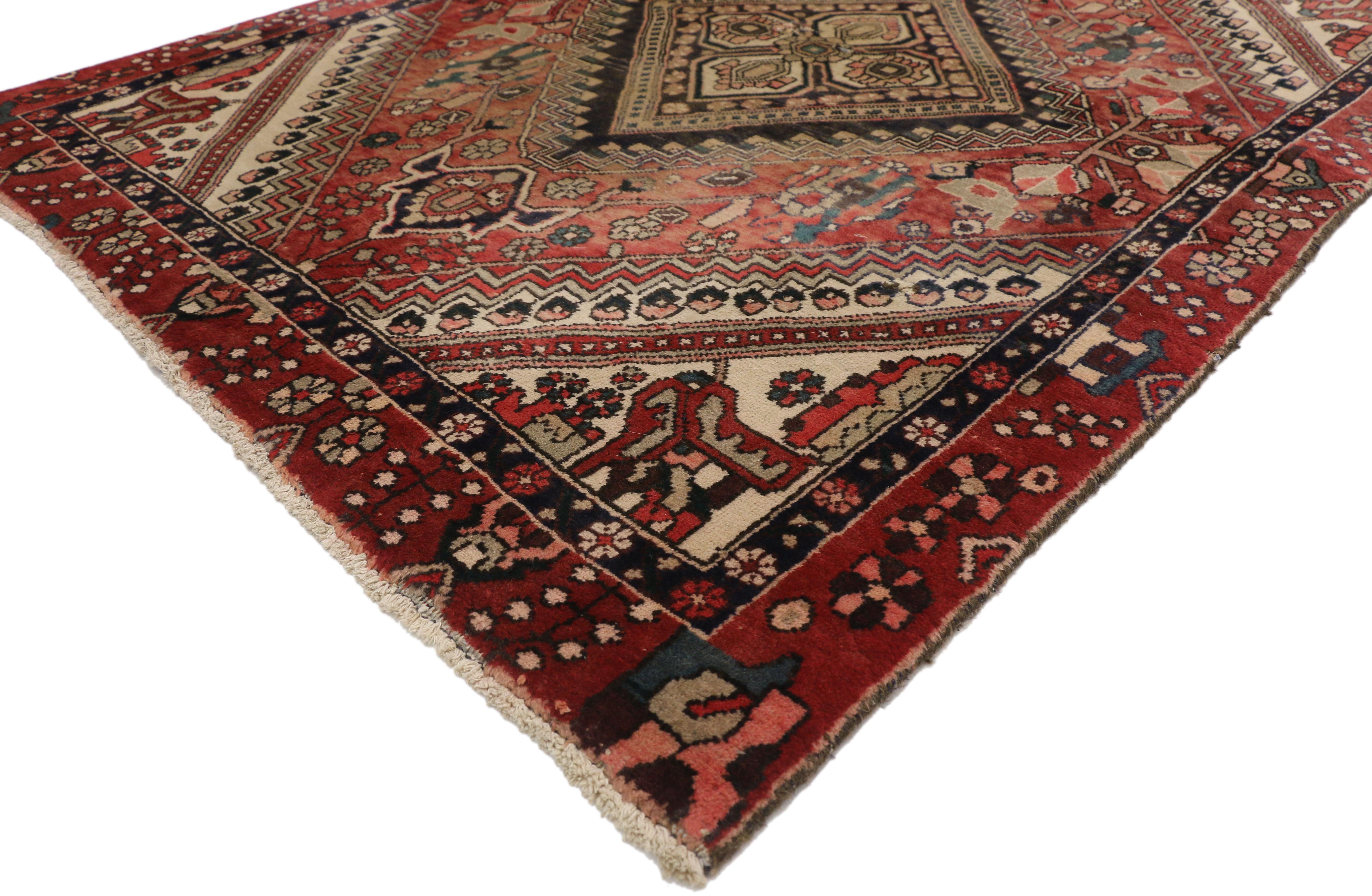 72118 Vintage Persian Shiraz rug with rustic traditional style. This hand knotted wool vintage Persian Shiraz rug features a diamond lozenge center medallion outlined with zigzag lines and flanked with a palmette finial at either end. The central