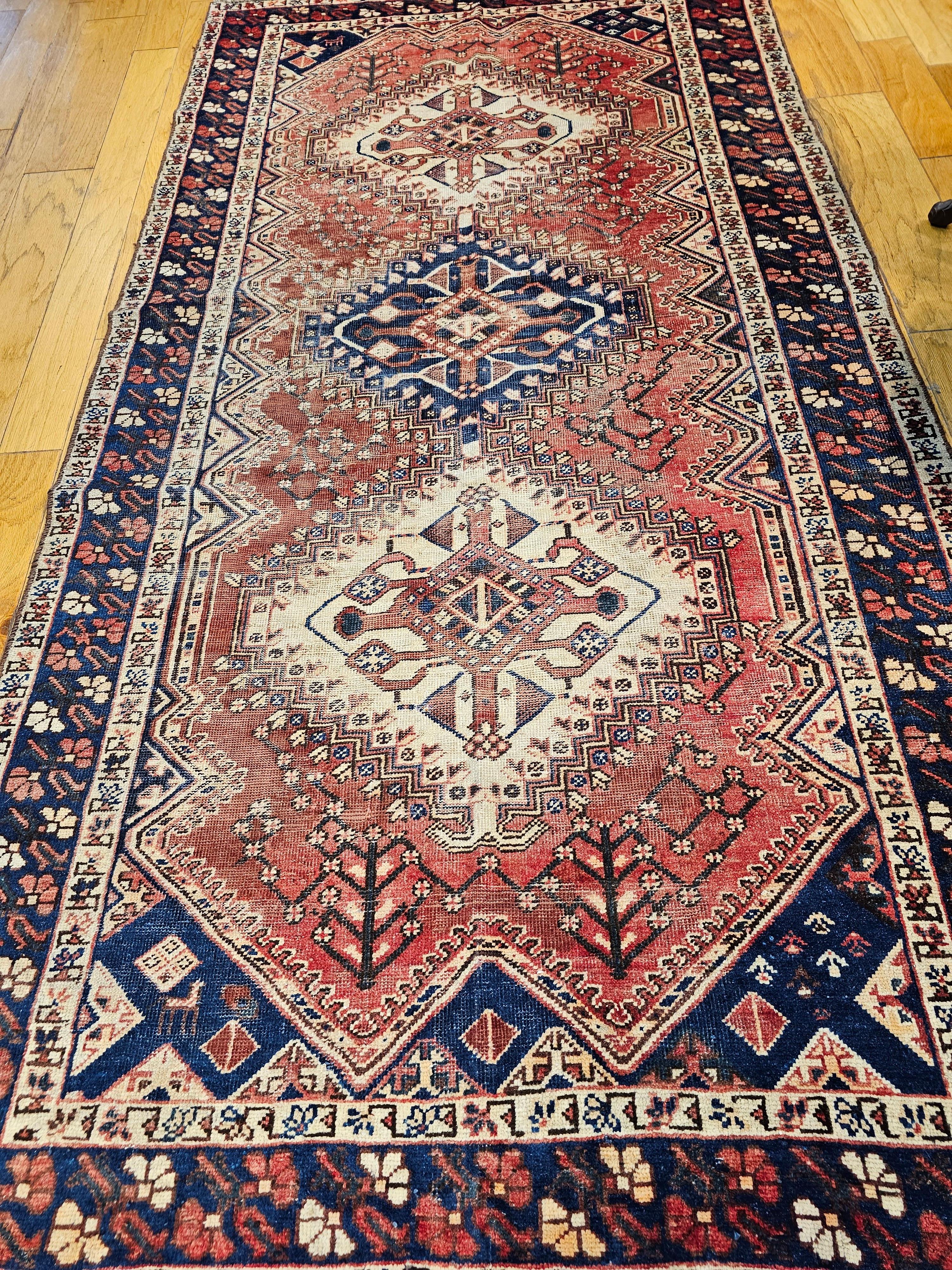  Vintage Persian Hand-Knotted gallery or room size rug from the Shiraz region of Western Persia circa the early 1900s.  The tribal design rug, similar to Qashqai rugs, comes with traditional three vertical medallions which is “Shiraz Signature”