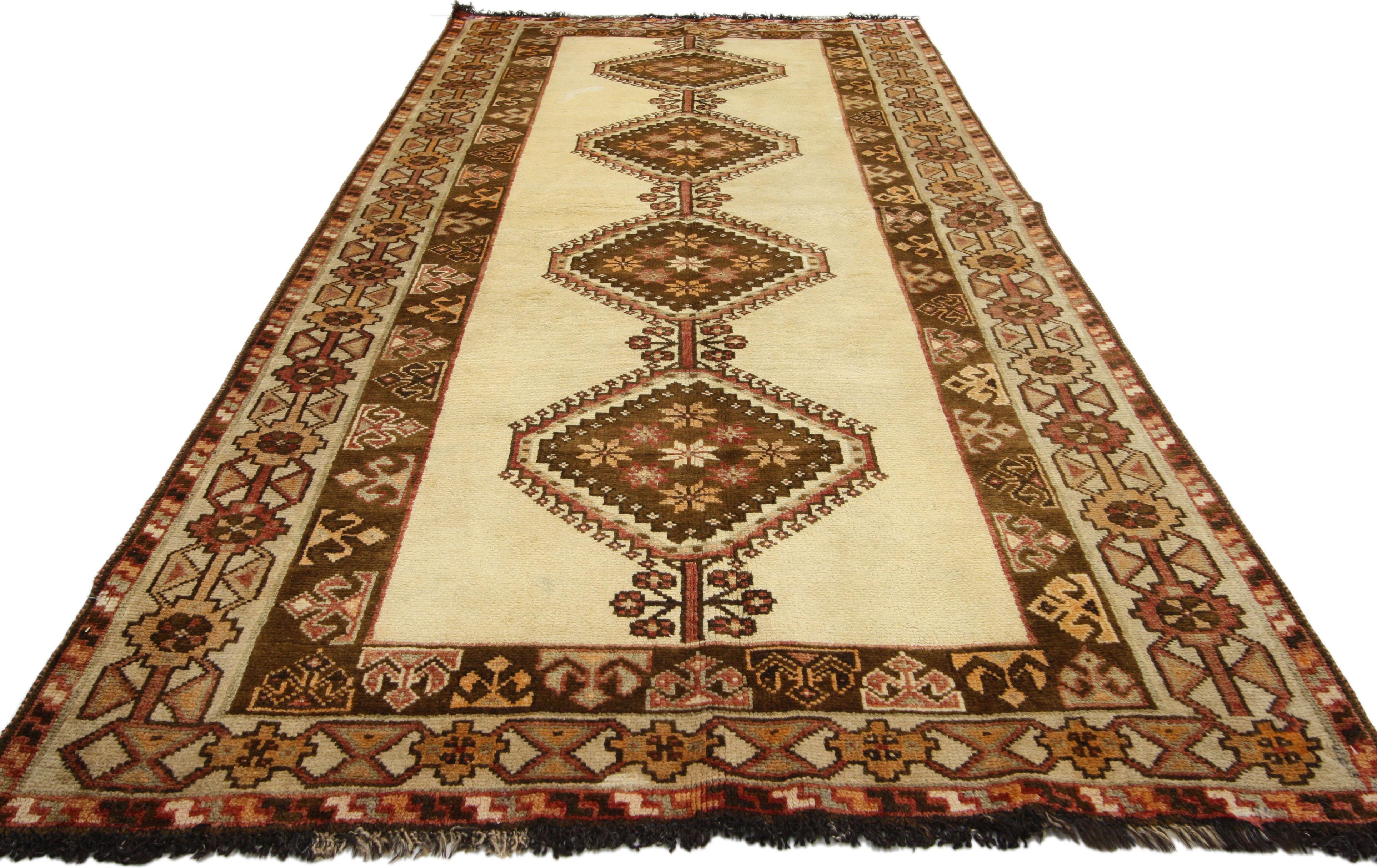 75040 Vintage Persian Shiraz Tribal Teppich mit Mid-Century Modern Stil und warmen Farben. Dieser handgeknüpfte alte persische Shiraz-Teppich aus Wolle zeigt vier sich wiederholende, übereinanderliegende geometrische Medaillons in einem offenen