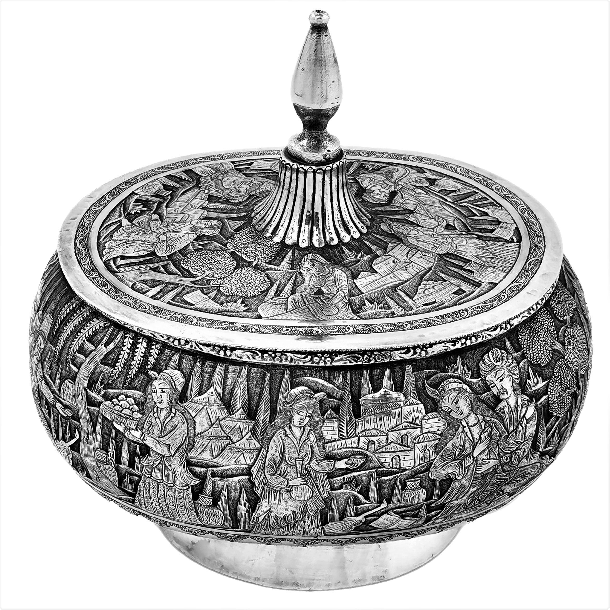 A beautiful vintage Persian solid Silver Lidded Container with an oval shape and a tall pointed lid. The body of the Box and the surface of the lid are embellished with rich, ornate chased designs showing figures in an out door setting with
