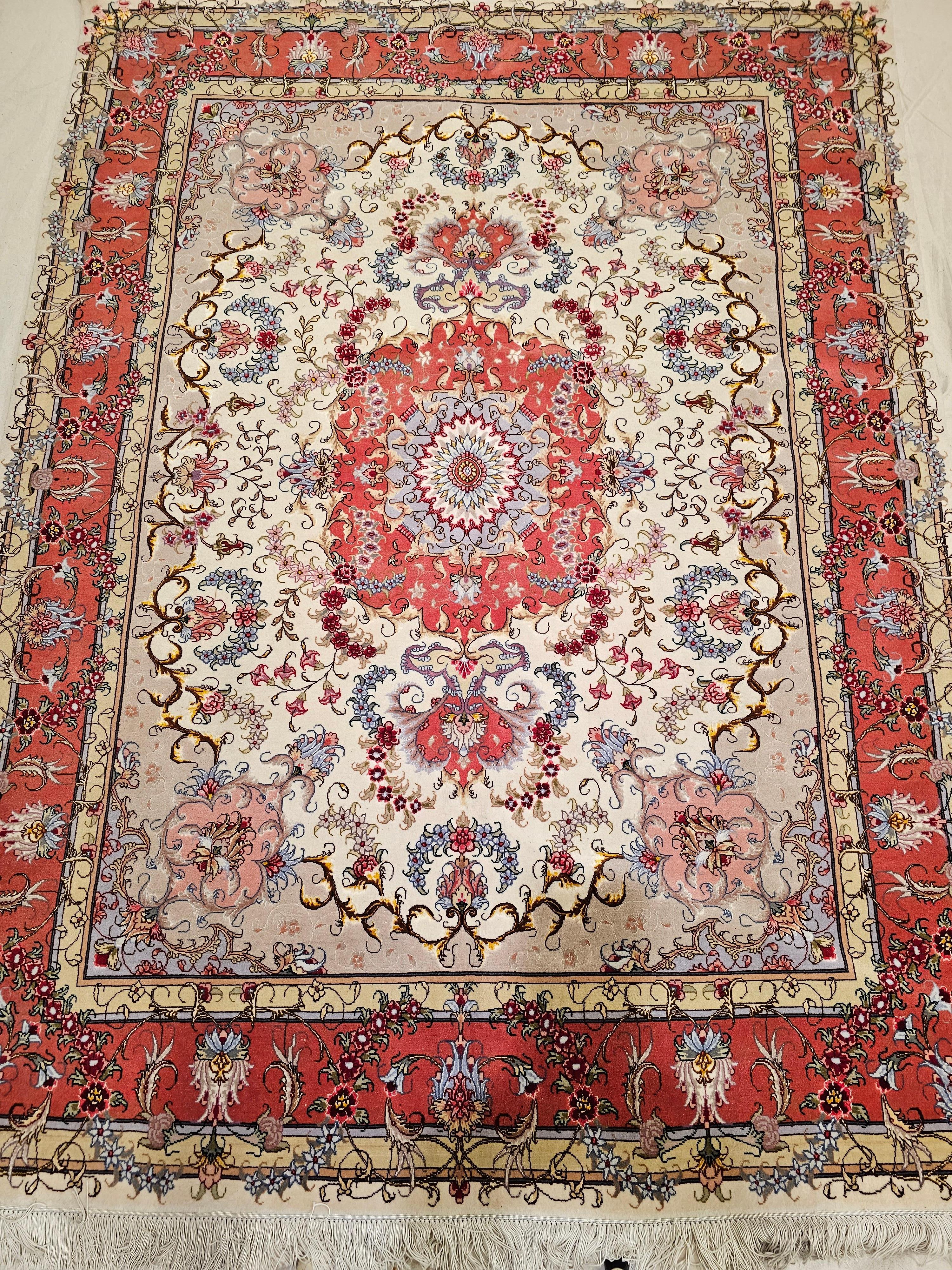 This finely woven Persian Tabriz area rug from the late 1900s showcases the timeless elegance of the classic floral 