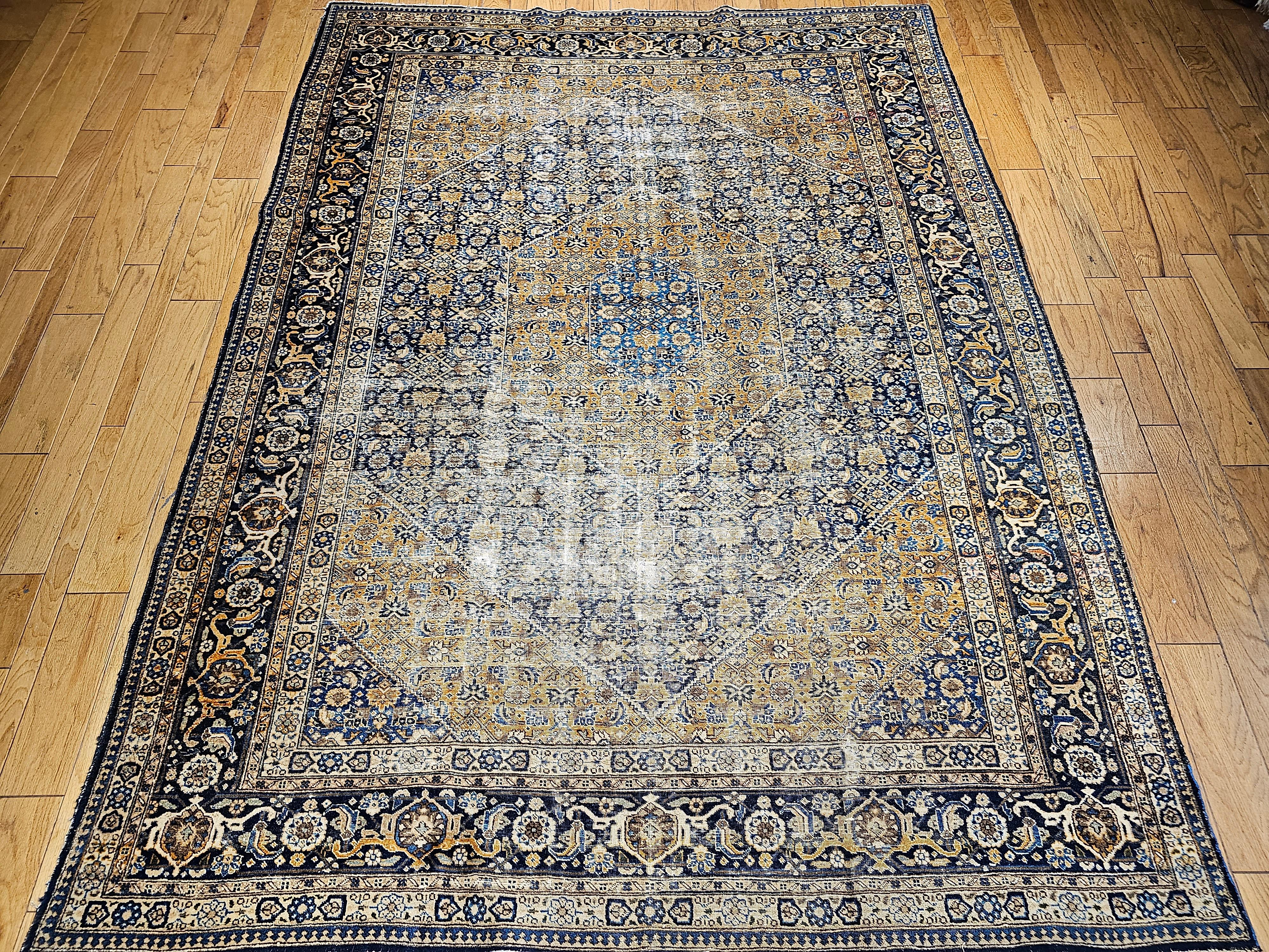 A Persian Tabriz rug from the early 1900s with a medallion Herati design.  The beautiful all-over Herati pattern is set in an abrash Navy blue background color with the corner spandrels in a combination of antique Camel and French blue colors.  The