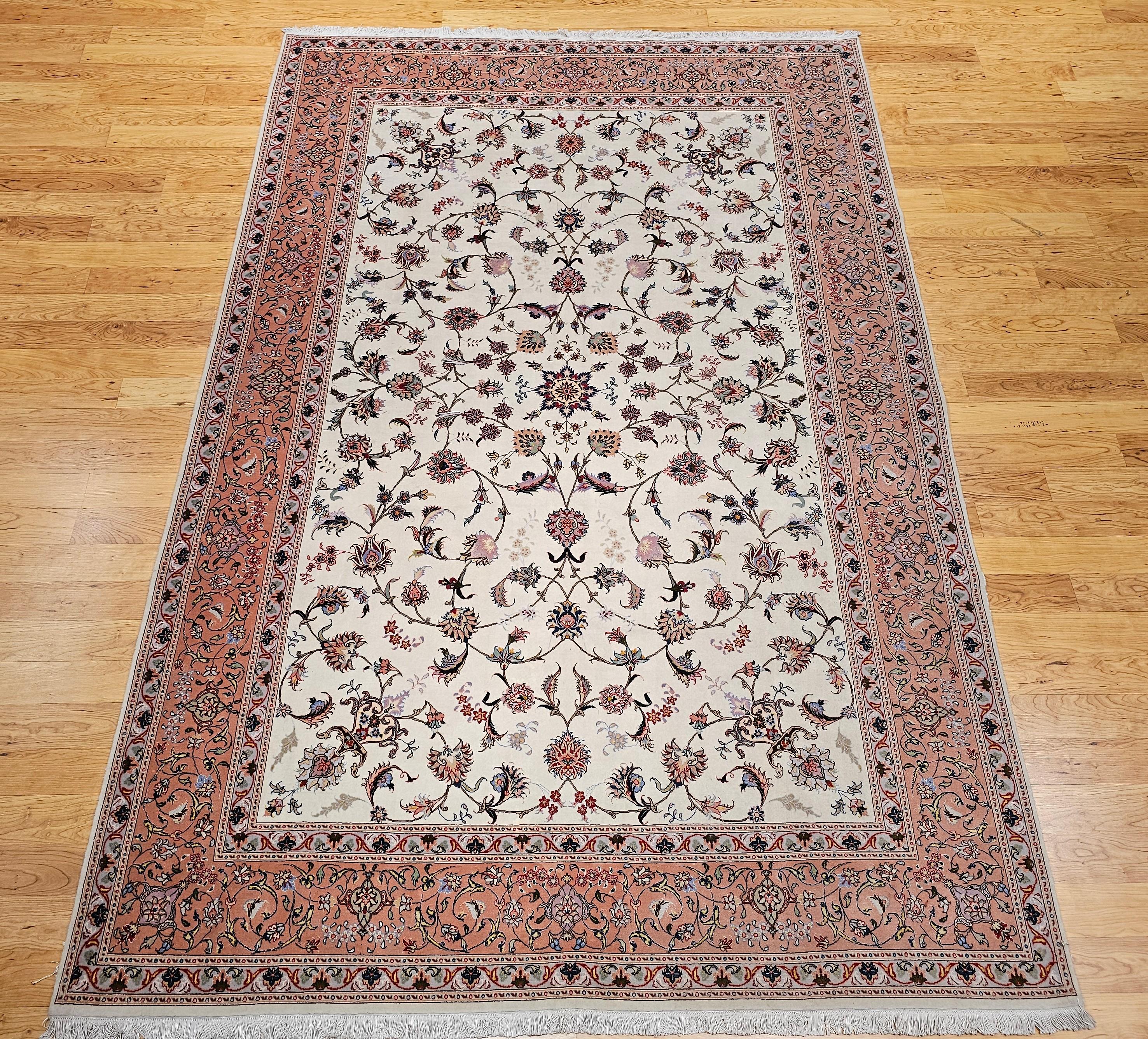 Wonderfully graceful and understatedly beautiful fine weave Persian Tabriz room size rug in an allover floral pattern with an ivory color background and a pale pink border.  It is artistically woven with a wool pile on a cotton foundation with silk