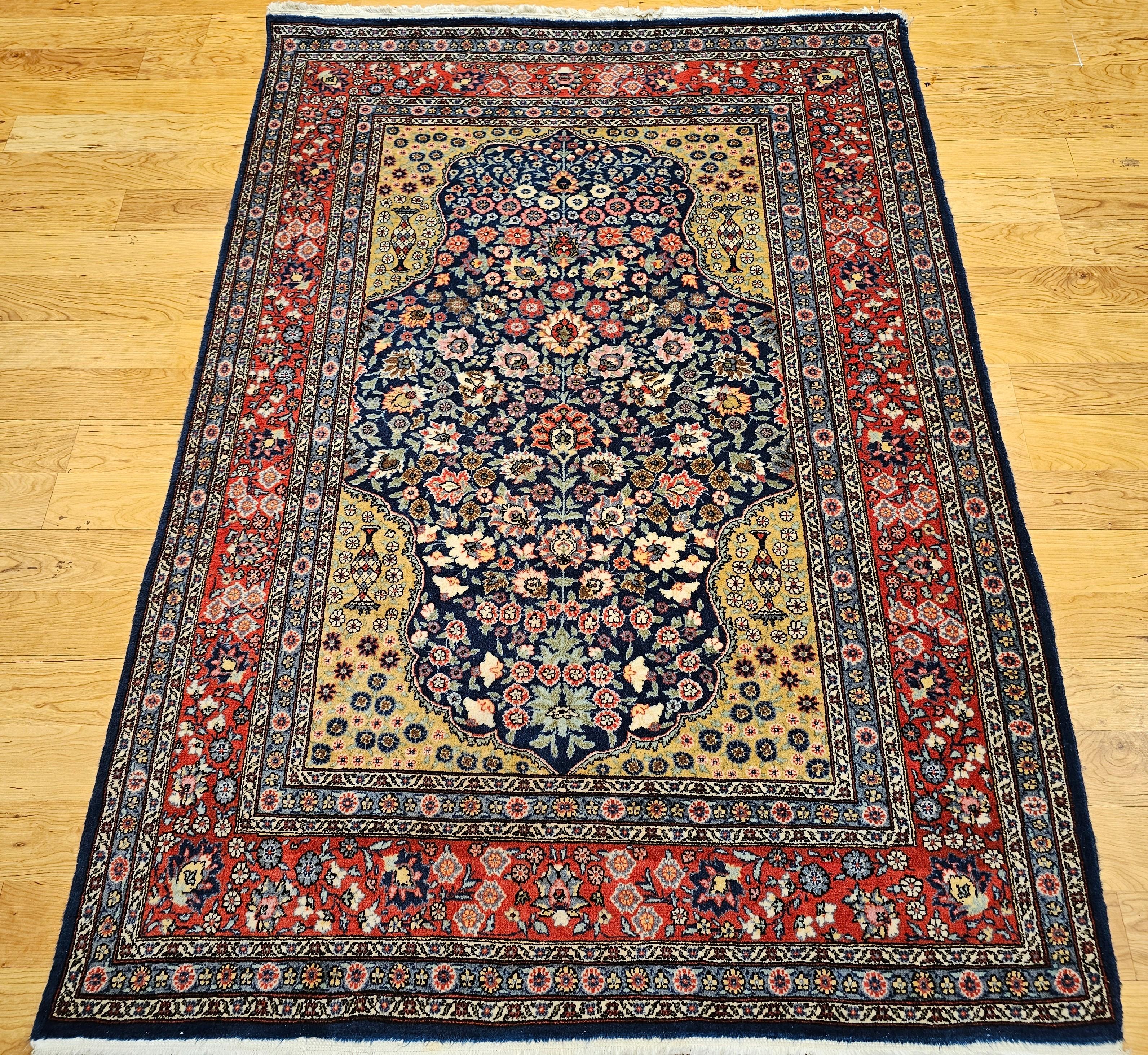 Ce tapis persan Tabriz vintage du milieu du 20e siècle présente un motif floral exquis, noué à la main avec précision et soin. Le tapis présente un fond bleu marine profond, créant un contraste saisissant avec les éléments floraux vibrants et variés