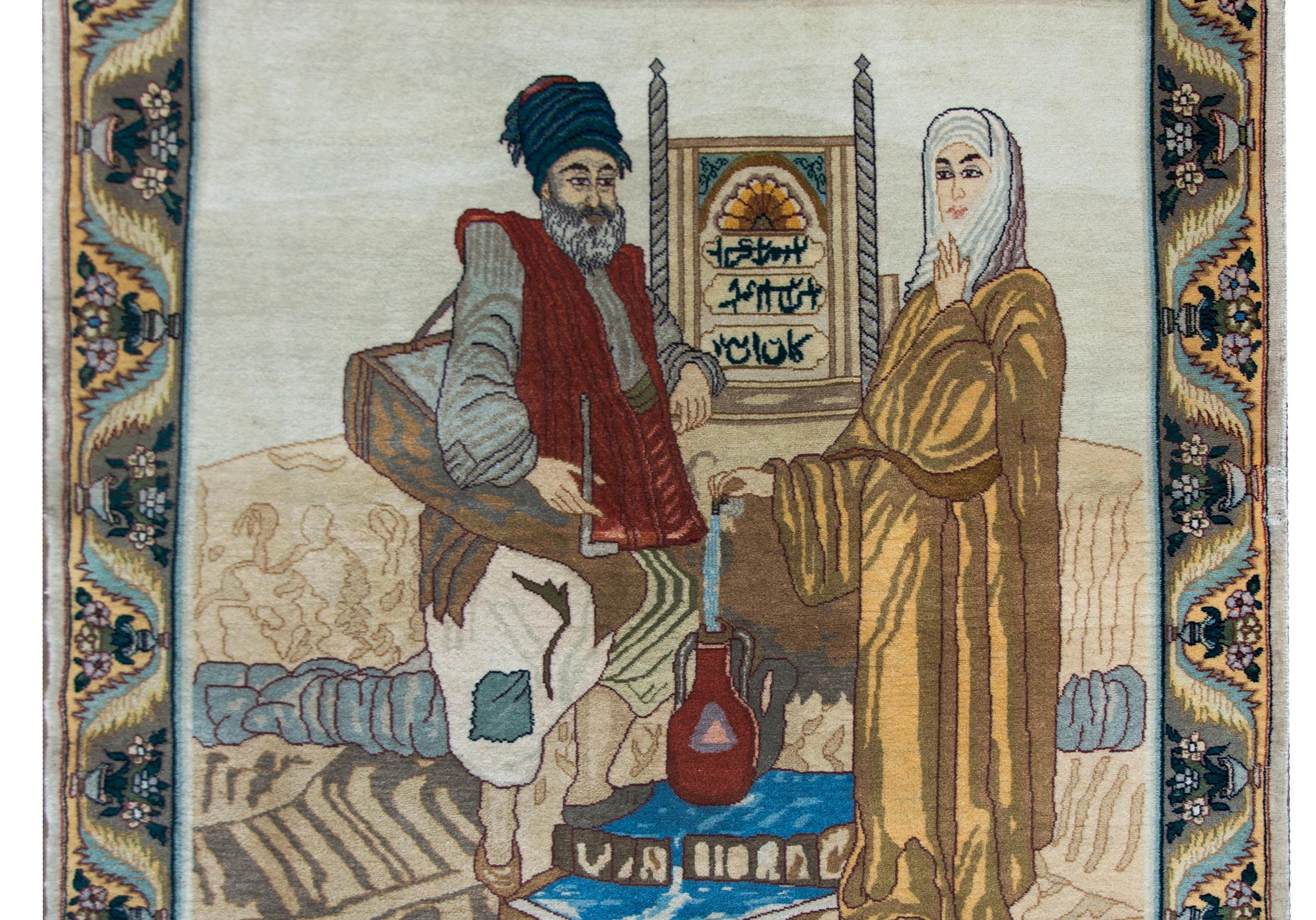 A beautiful late 20th century Persian Tabriz pictorial rug depicting a man and woman standing near a fountain and filling a pitcher of water, and all woven in beautiful crimson, gold, blue and various browns and beige colored wools.