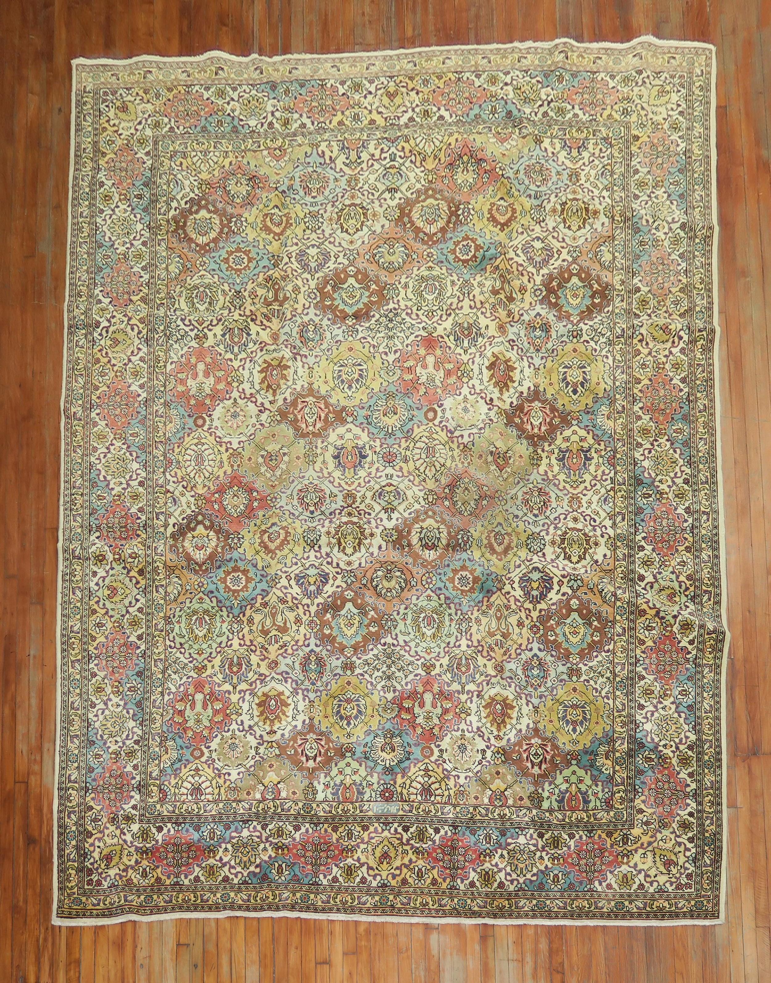 A mid 20th-century all-over pattern Persian Tabriz rug with an array of colors on a creamy yellow field.

Measures: 9'6'' x 13'.