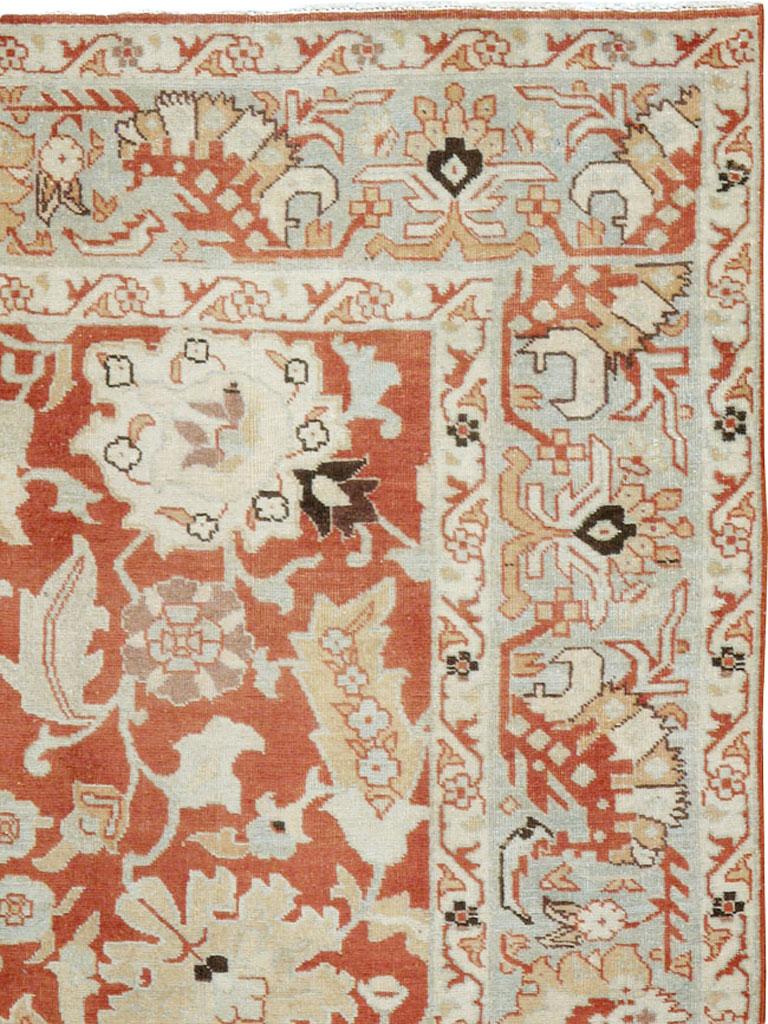 Ein alter persischer Täbriz-Teppich aus der Mitte des 20. Jahrhunderts. Obwohl es eine vertikale Mittelachse gibt, unterscheiden sich die aufgereihten Palmetten auf dem Ziegelgrund voneinander. Die Zeichnung der Hauptbordüren neigt zum Eckigen, fast