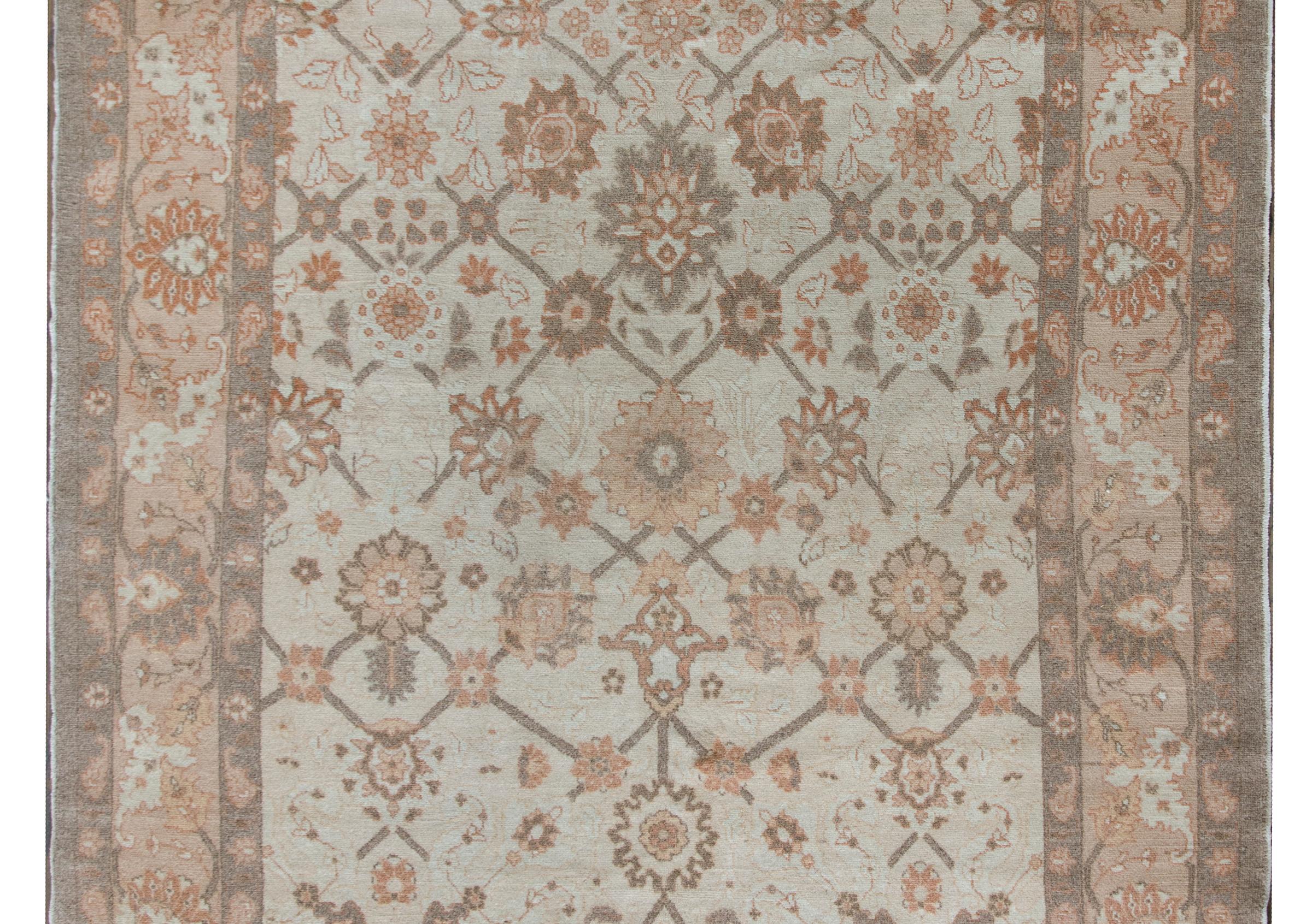 A chic late 20th century Persian Tabriz rug with a wonderful trellis floral pattern with the most wonderful large-scale flowers, surrounded by a wide border with multiple floral and scrolling vine patterns, and all woven in muted grays, browns, and