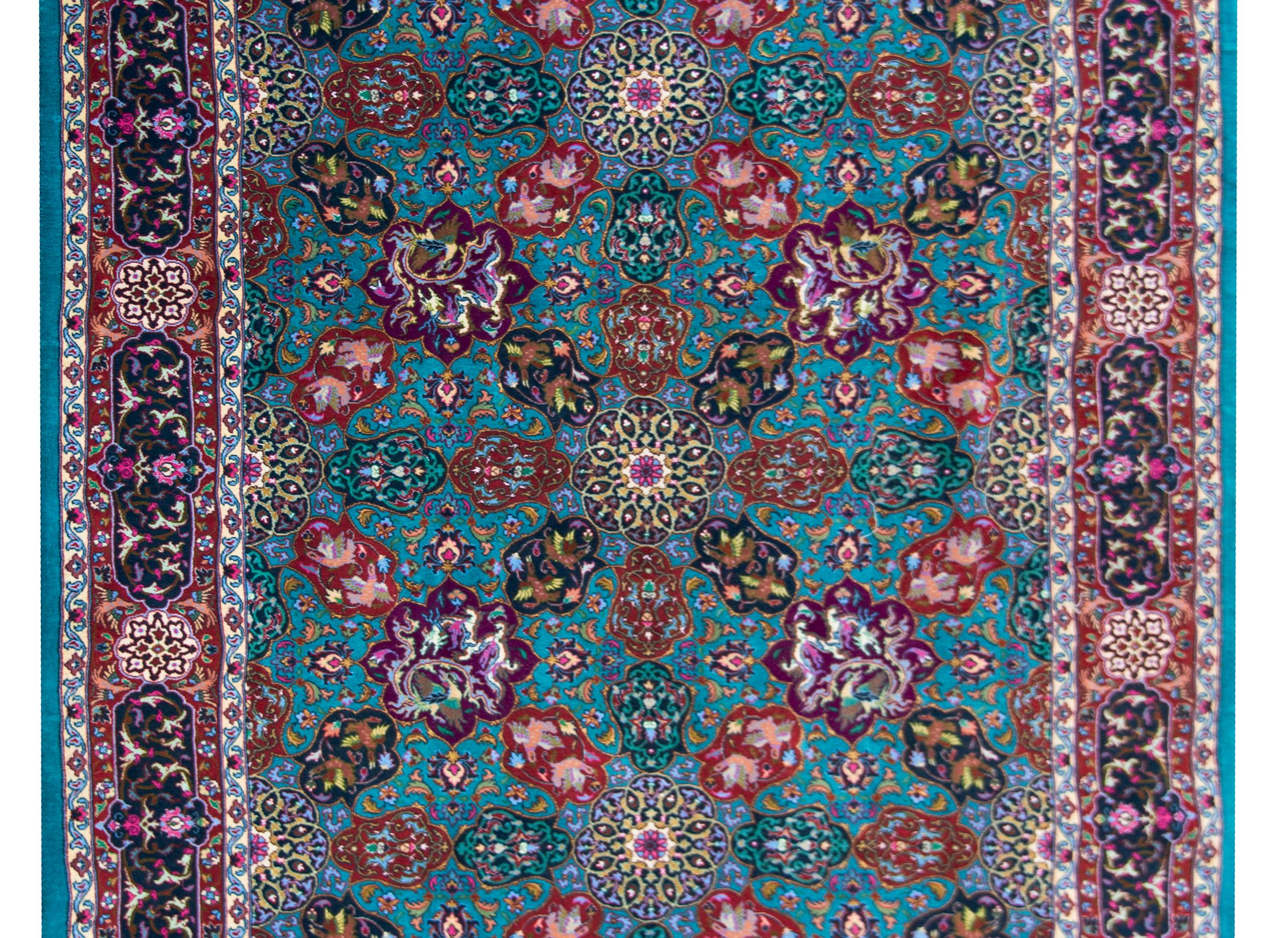 A late 20th century Persian Tabriz rug with the most wonderful mirrored stylized floral pattern woven in brilliant pinks, violets, golds, greens, crimsons, and all set against a teal background. The border is wide with a repeated large-scale floral