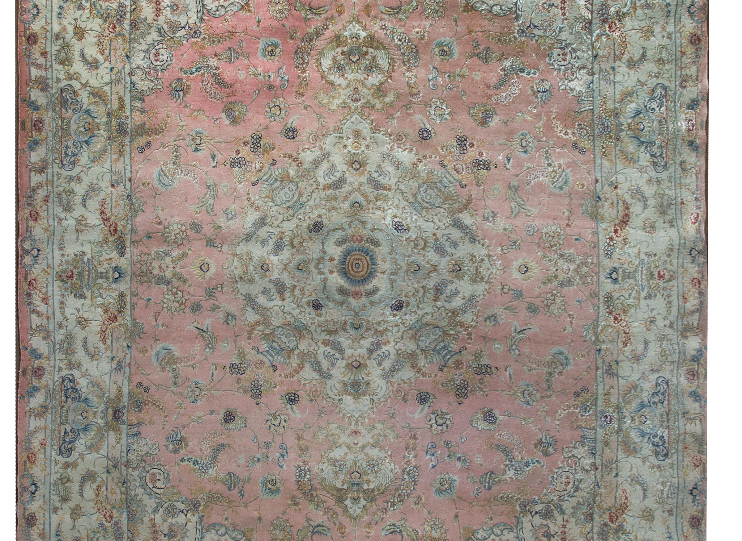 An extraordinary late 20th century Persian Tabriz rug with a large central floral medallion with myriad flowers and a vase with flowers in each corner, and living amidst a field of more flowers, and surrounded by an incredible wide repeated floral