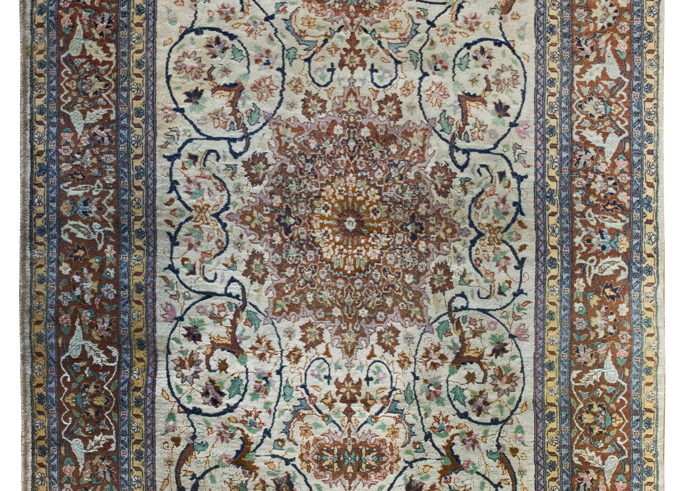 Un tappeto persiano Tabriz della metà del XX secolo, questo capolavoro è una testimonianza della tradizione secolare di tessitura della regione. Al centro, un ipnotico medaglione floreale centrale sboccia e si irradia verso l'esterno in un campo