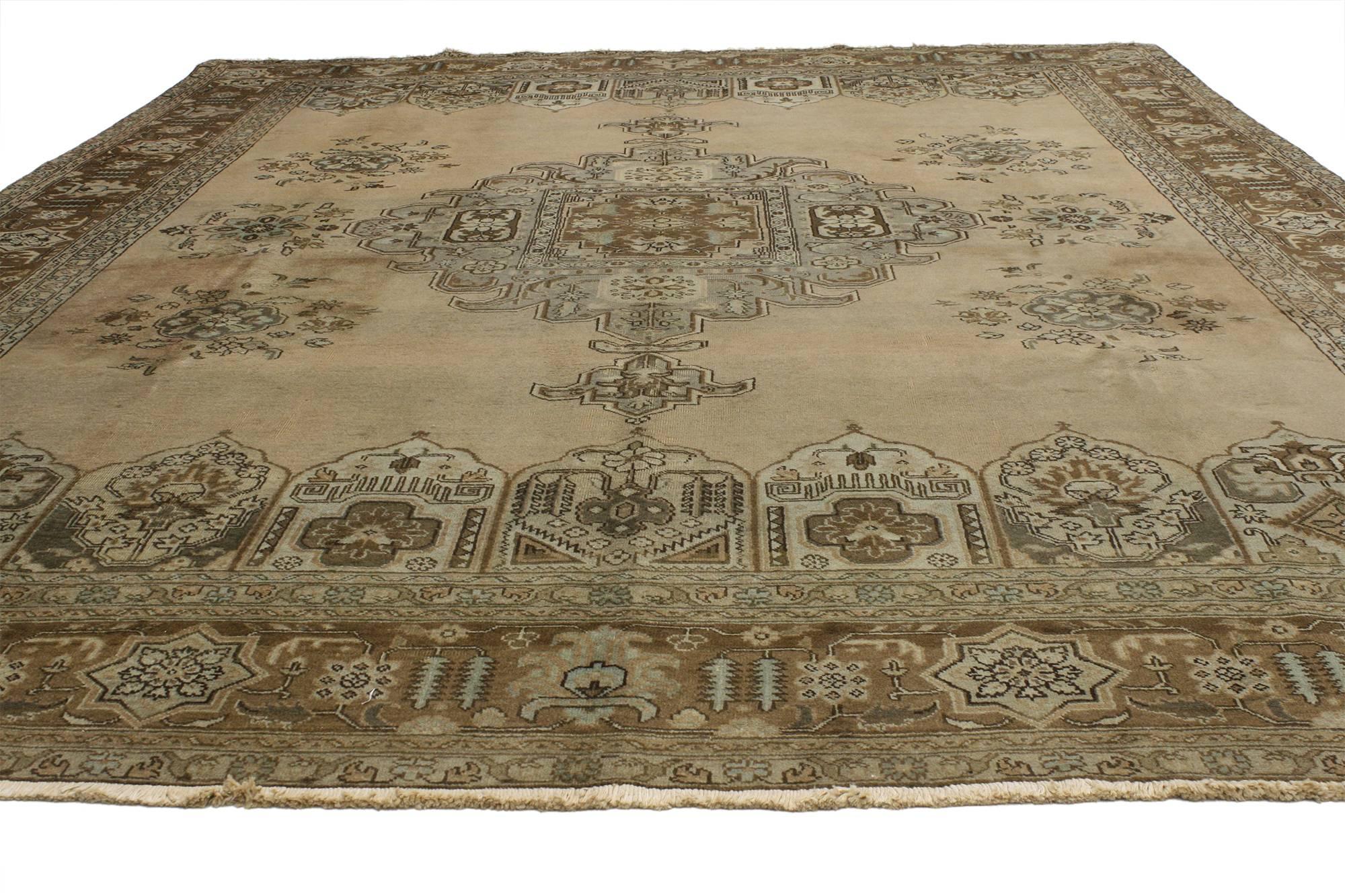 75767, tappeto persiano Tabriz vintage dallo stile tradizionale. Questo tappeto Tabriz persiano vintage in lana annodato a mano presenta un medaglione centrale punteggiato da bouquet floreali in un campo aperto abrasivo circondato da un bordo