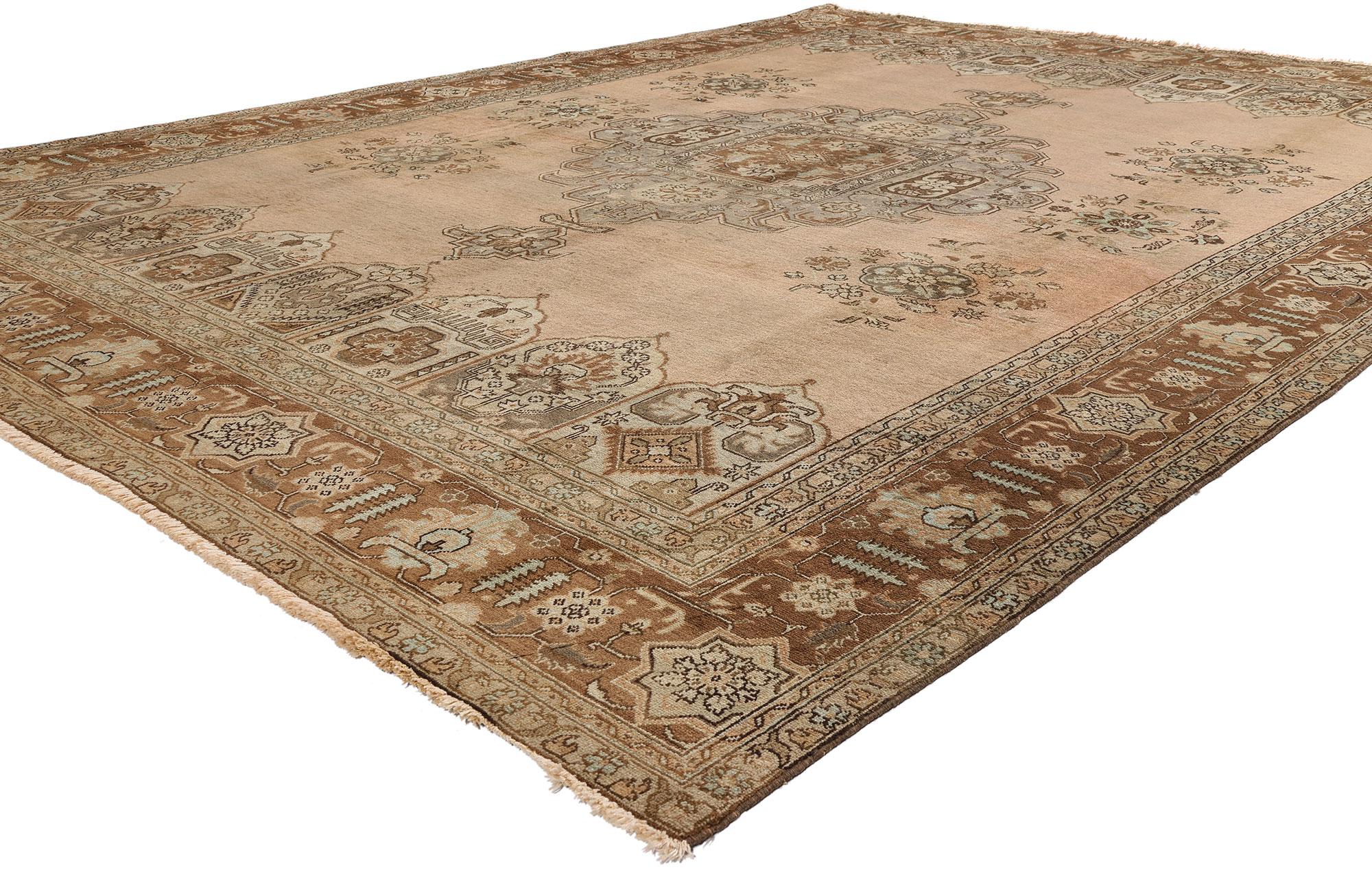 75767, Alfombra persa Tabriz vintage de estilo tradicional. Esta alfombra persa Tabriz vintage de lana anudada a mano presenta un medallón central salpicado de ramilletes florales en un campo abrasivo abierto rodeado por un borde clásico que crea un